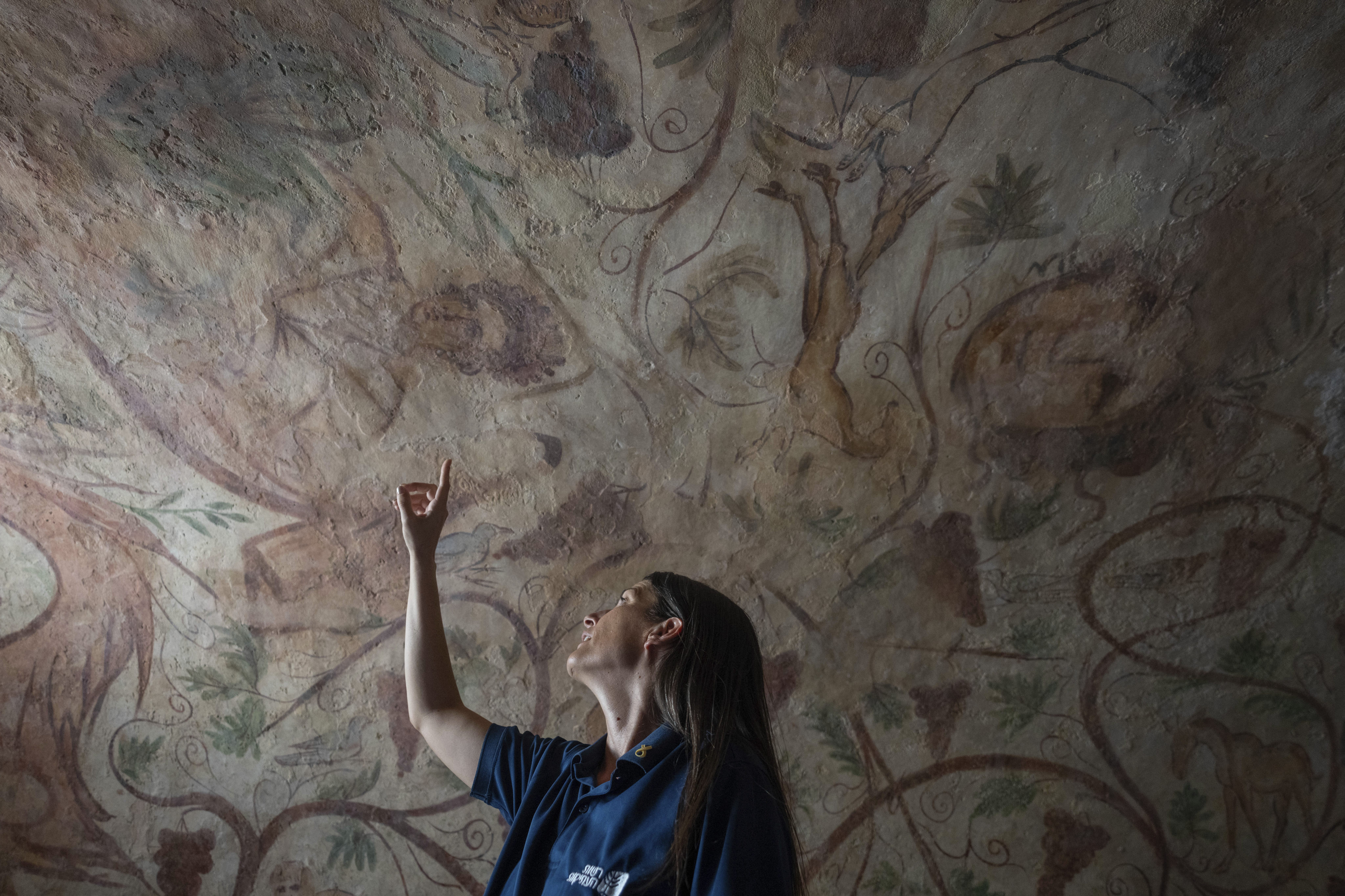 A worker points to an ancient wall of the archeological tomb site in Ashkelon, Israel on Tuesday. Photo: AP