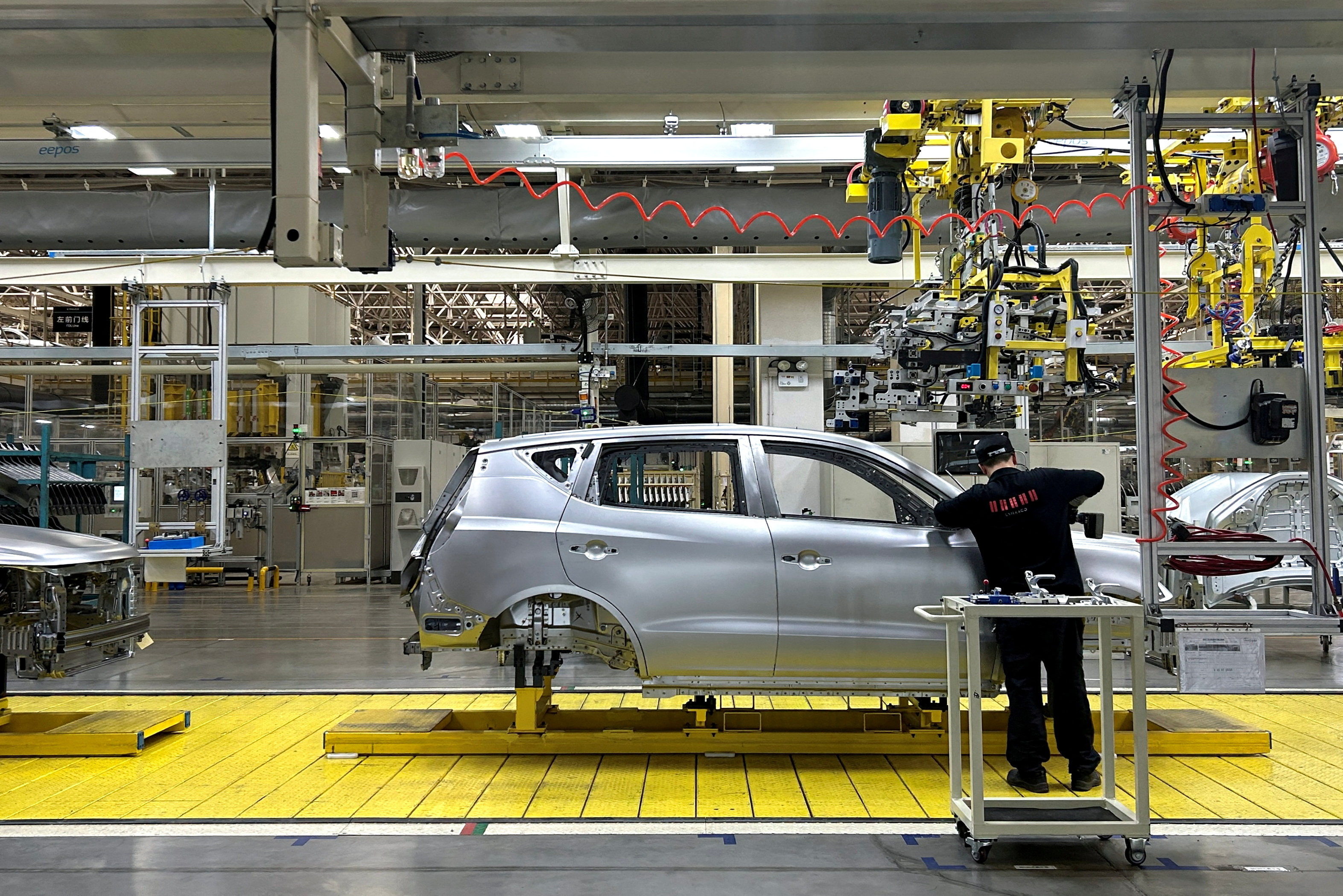 An employee works on an assembly line manufacturing GX6 cars at the Geely plant in Chengdu, Sichuan province, on April 13, 2023. Photo: Reuters