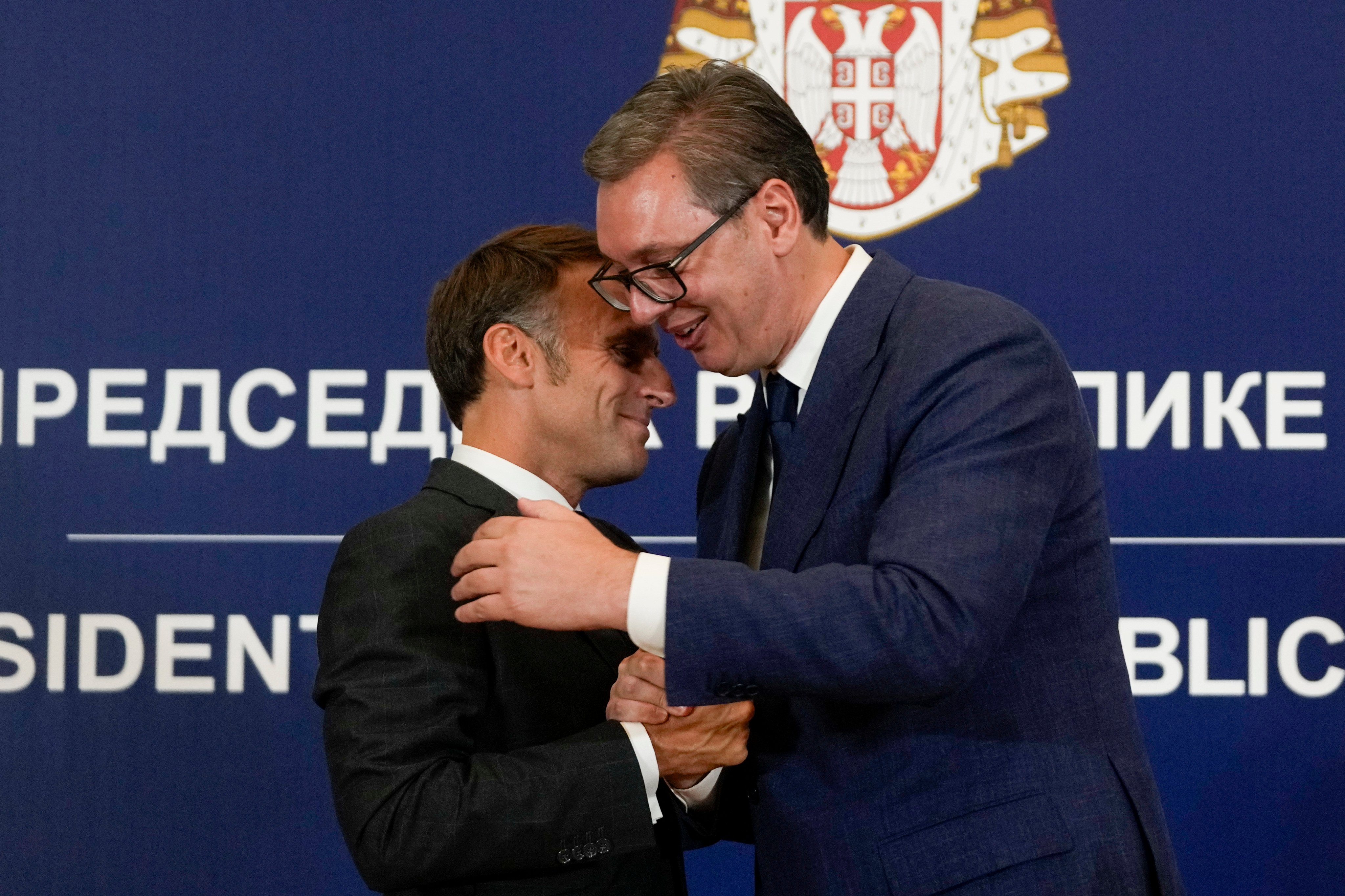 French President Emmanuel Macron clasps hands with Serbian President Aleksandar Vucic after a joint press conference. Photo: AP