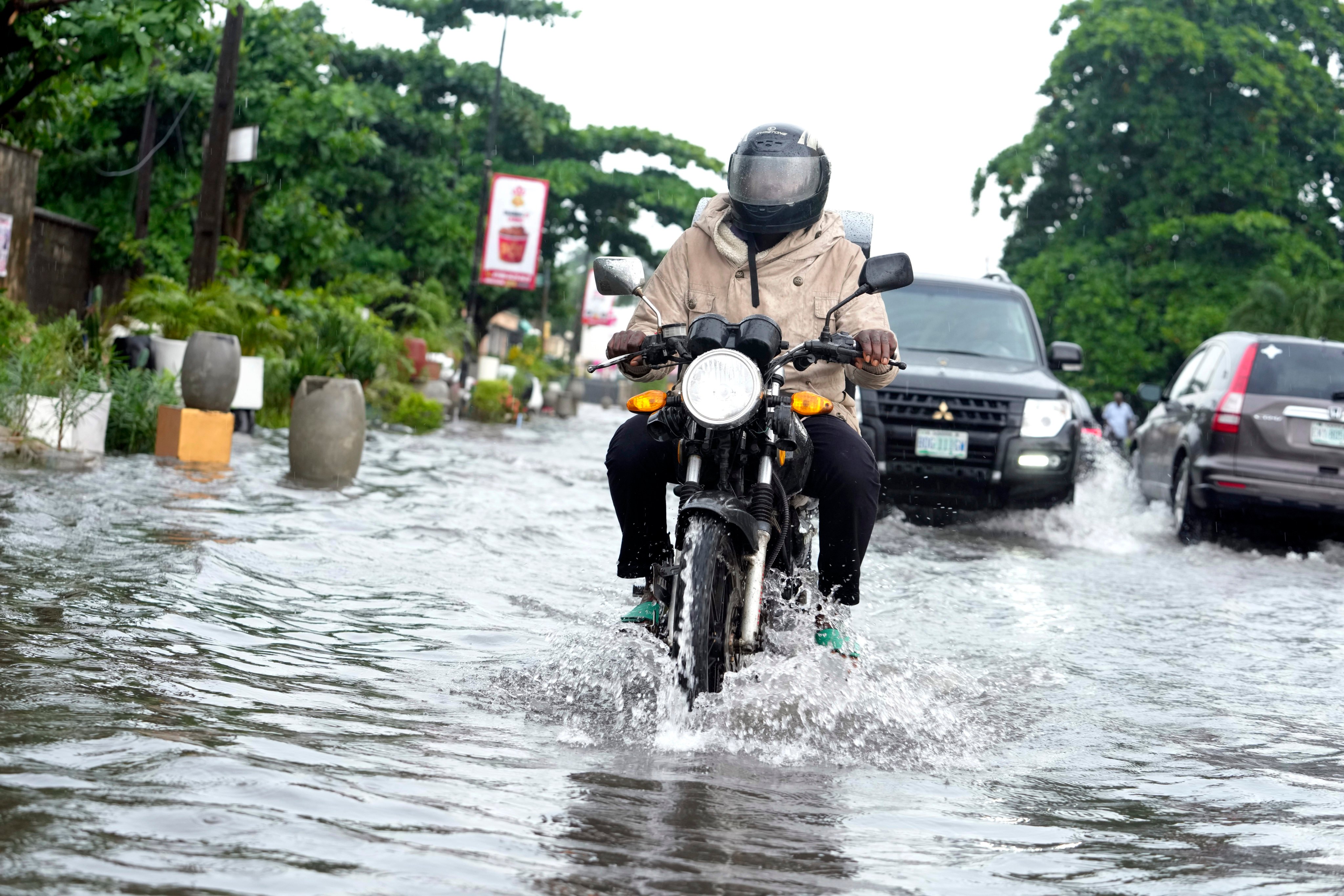 A motorcyclist rides through a flooded street after a heavy downpour in Lagos, Nigeria, July 10, 2024. Photo: AP