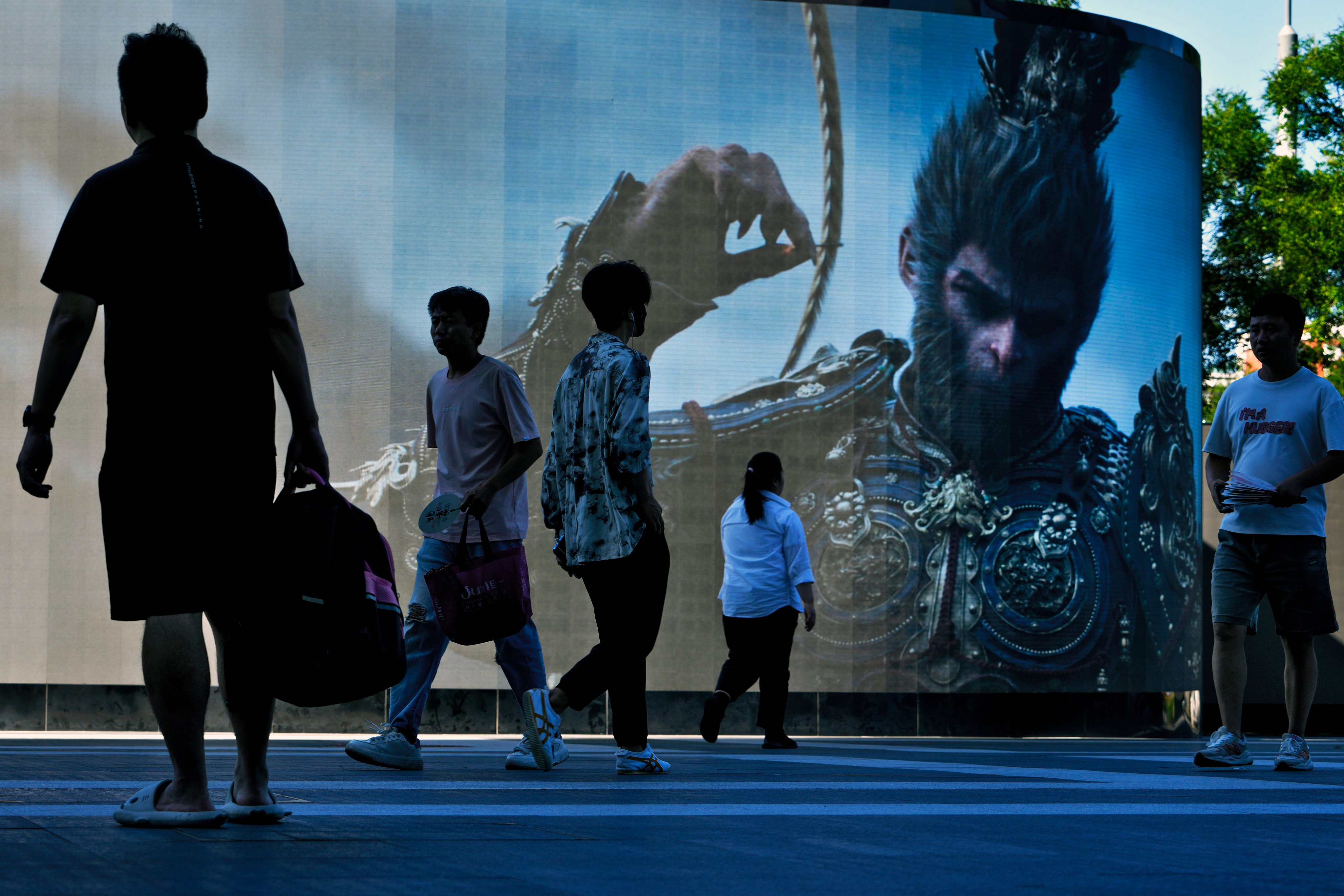 People walk past a large screen advertising China’s latest blockbuster video game, Black Myth: Wukong, outside a commercial office building in Beijing on August 27, 2024. Photo: AP