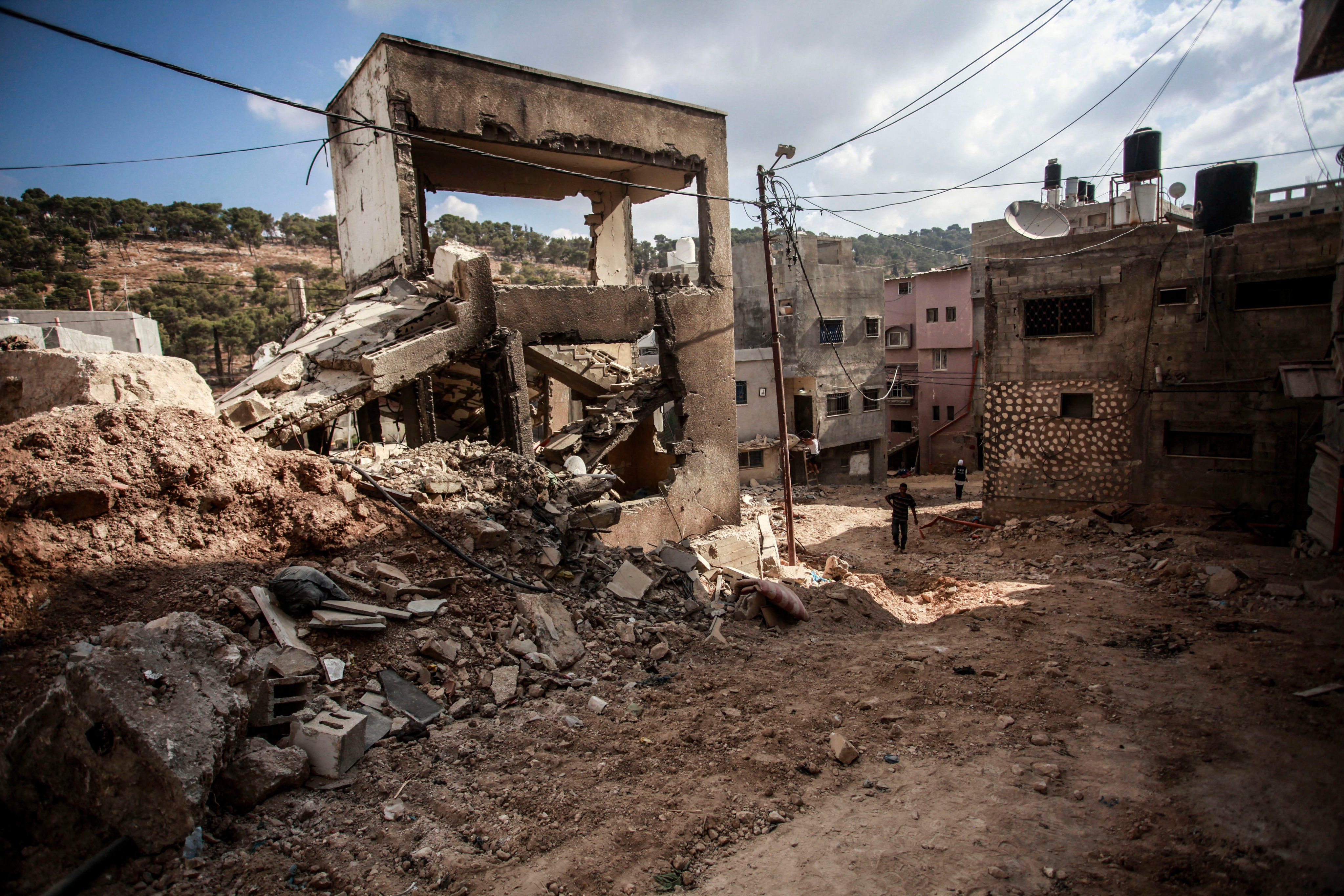 People walk past the devastation in the Nur Shams refugee camp in Tulkarem in the occupied-West Bank after a large-scale Israeli military operation. Photo: dpa