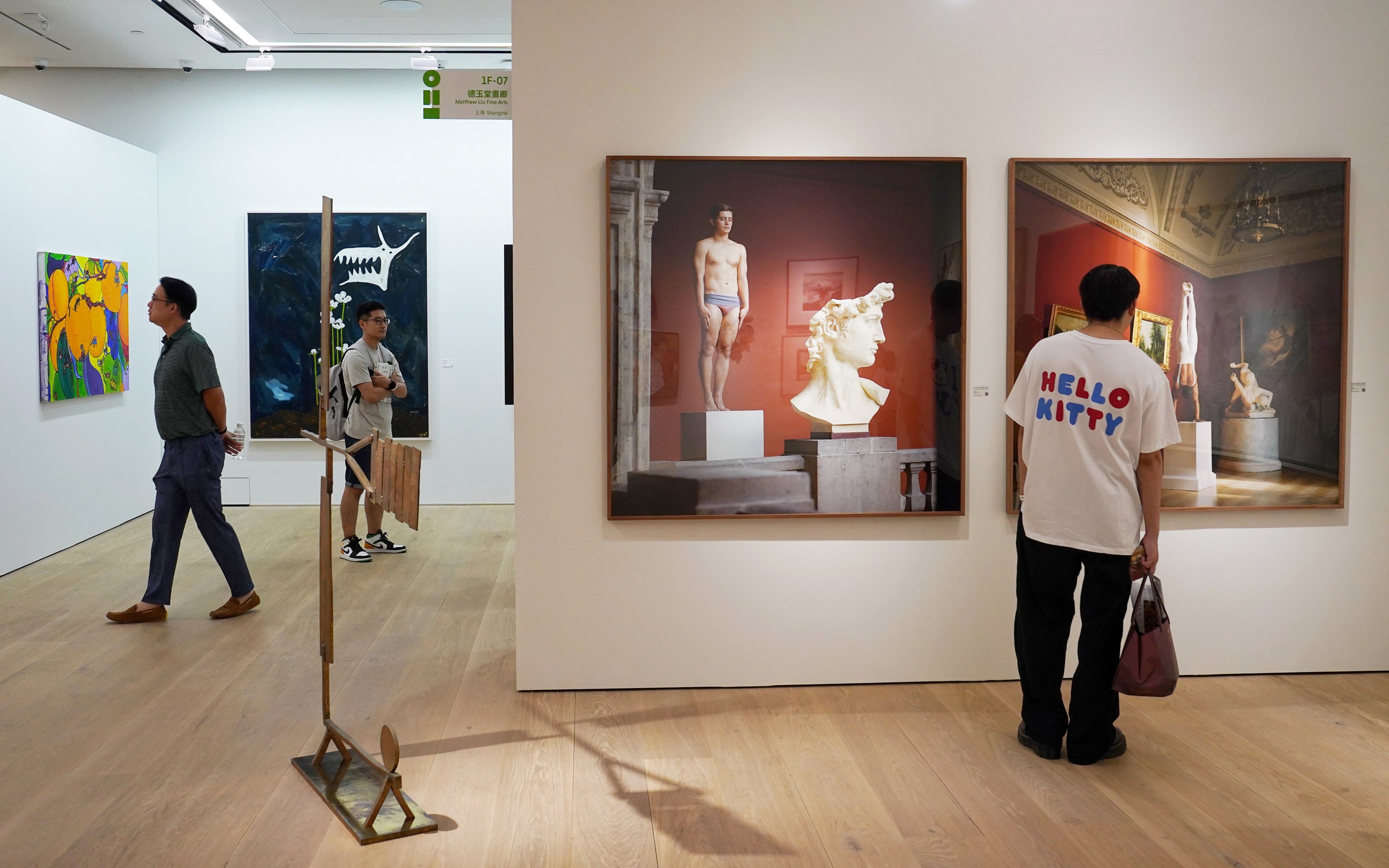 Viewers take a close look at artworks on display as part of the Art021 fair at the Philips Asia headquarters. Photo: Elson Li