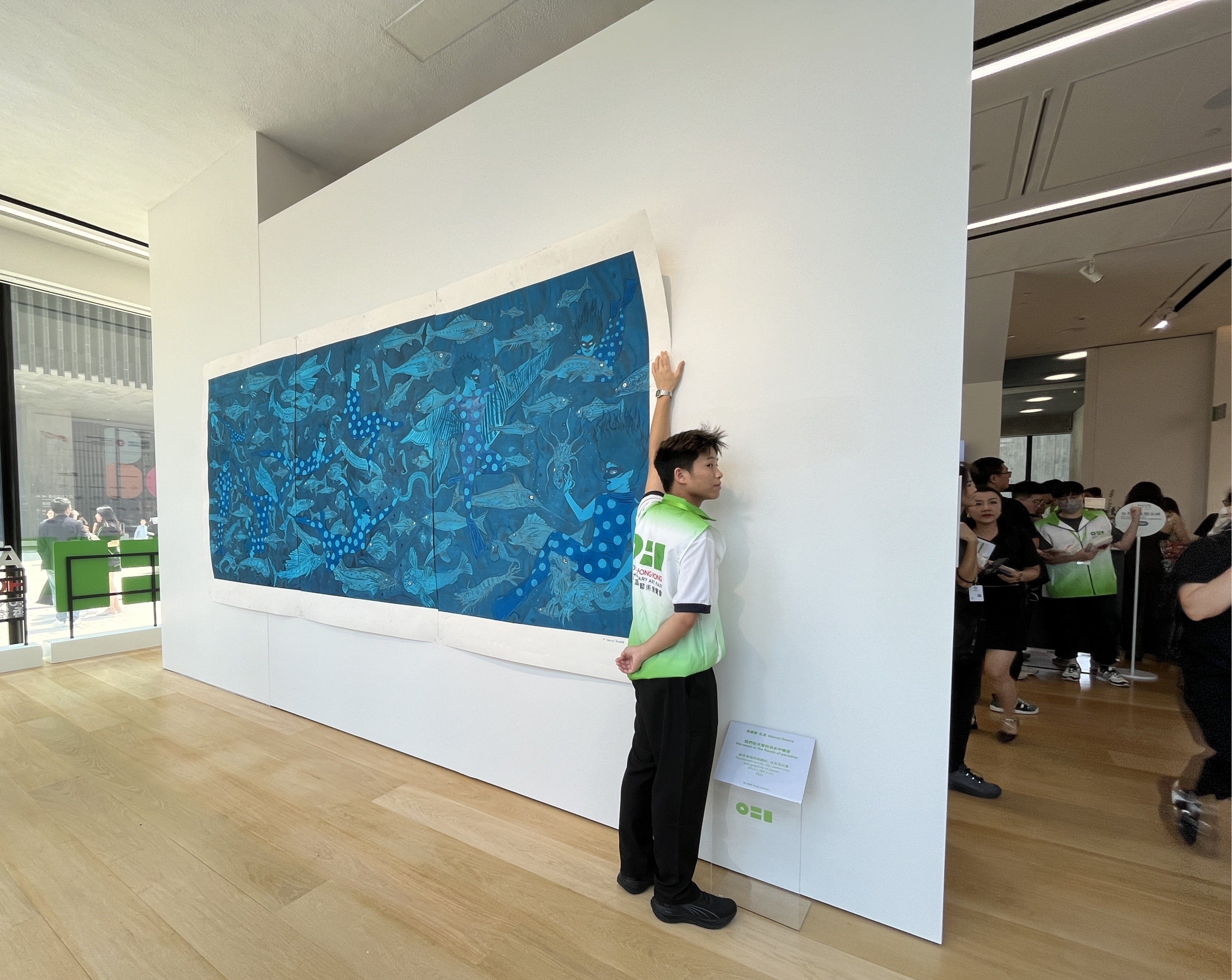 A member of staff holds up Marcel Dzama’s “We Swam in the Floods of Paradise” after it was partially blown off the wall at the inaugural Art021 Hong Kong Contemporary Art Fair, on August 29, 2024. Photo: Enid Tsui