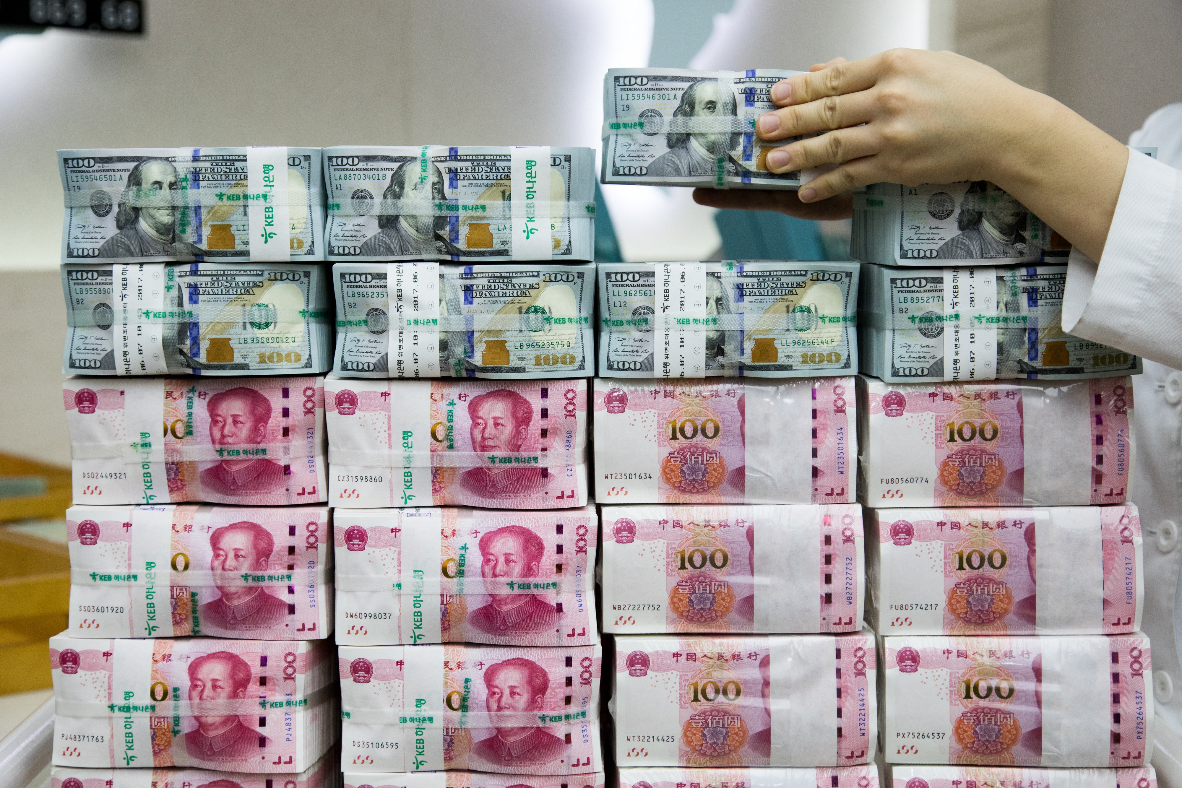 An employee arranges bundles of US dollar banknotes and Chinese yuan. Photo: Bloomberg