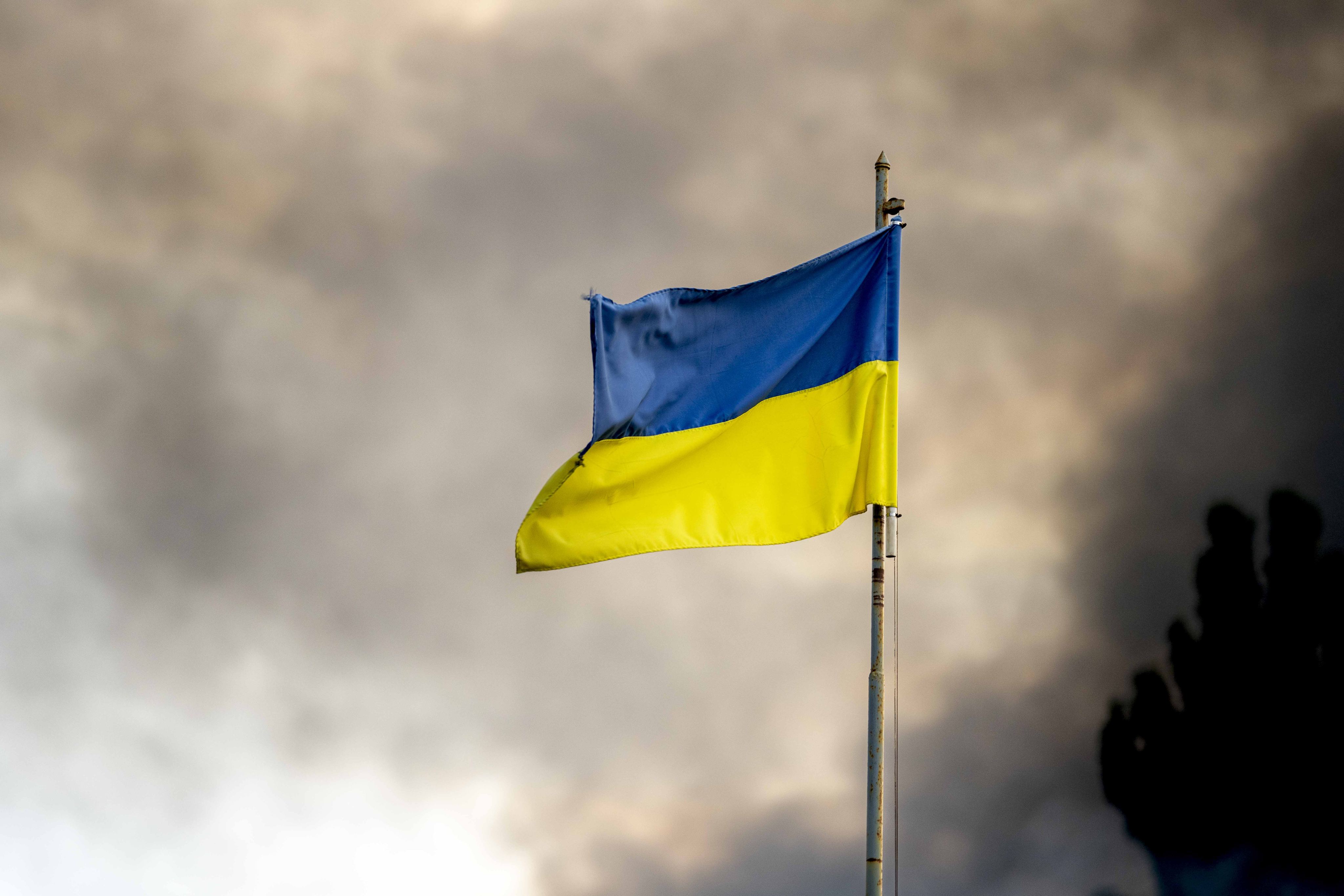 A Ukrainian flag seen in front of thick smoke rising from a fire over Kyiv after Russian missile attacks on Ukraine. Photo: Zuma Press Wire/dpa