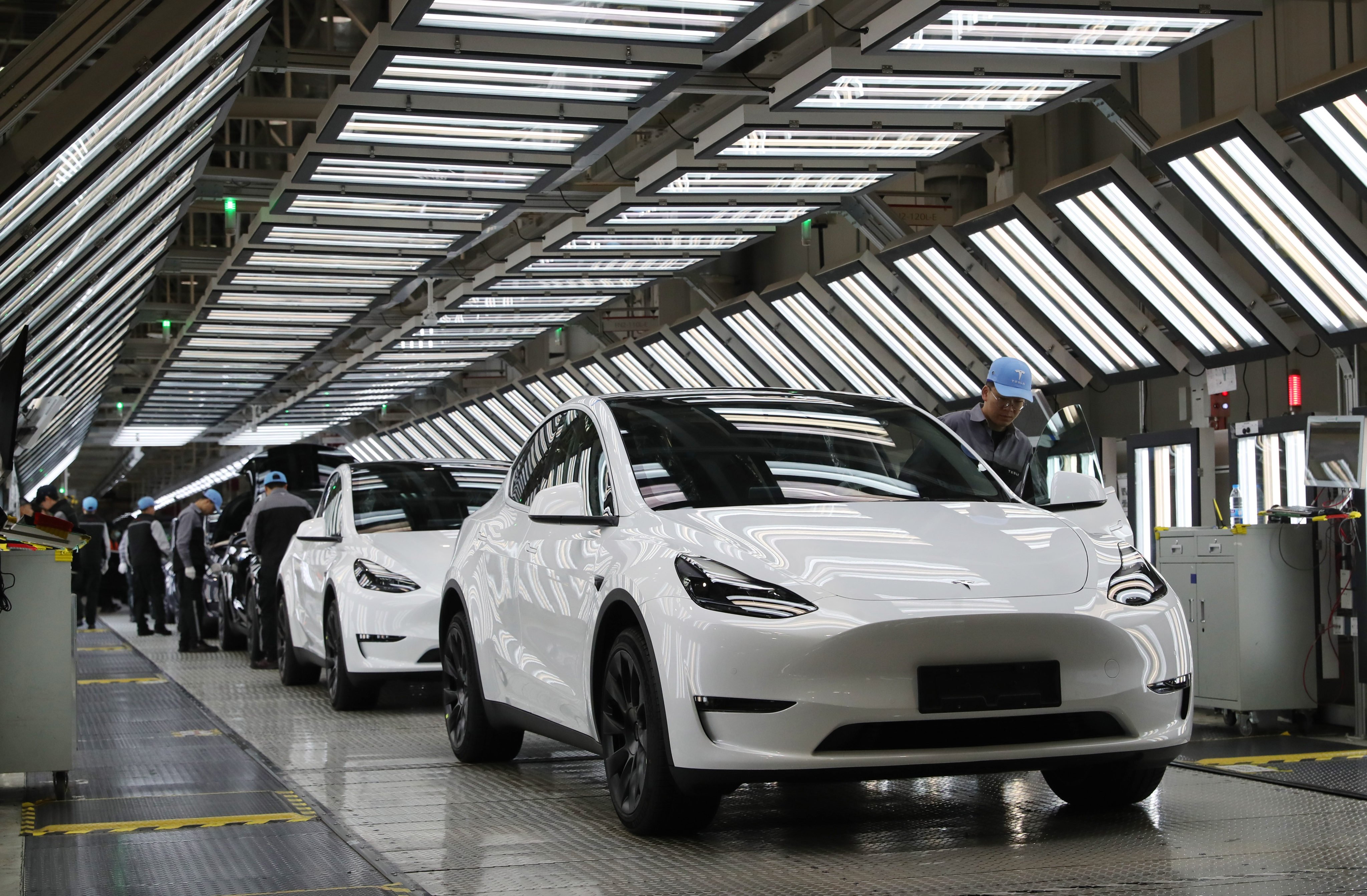 Workers check Tesla EVs rolling off the assembly line at the company’s Gigafactory in Shanghai on December 22, 2023. Photo: Xinhua