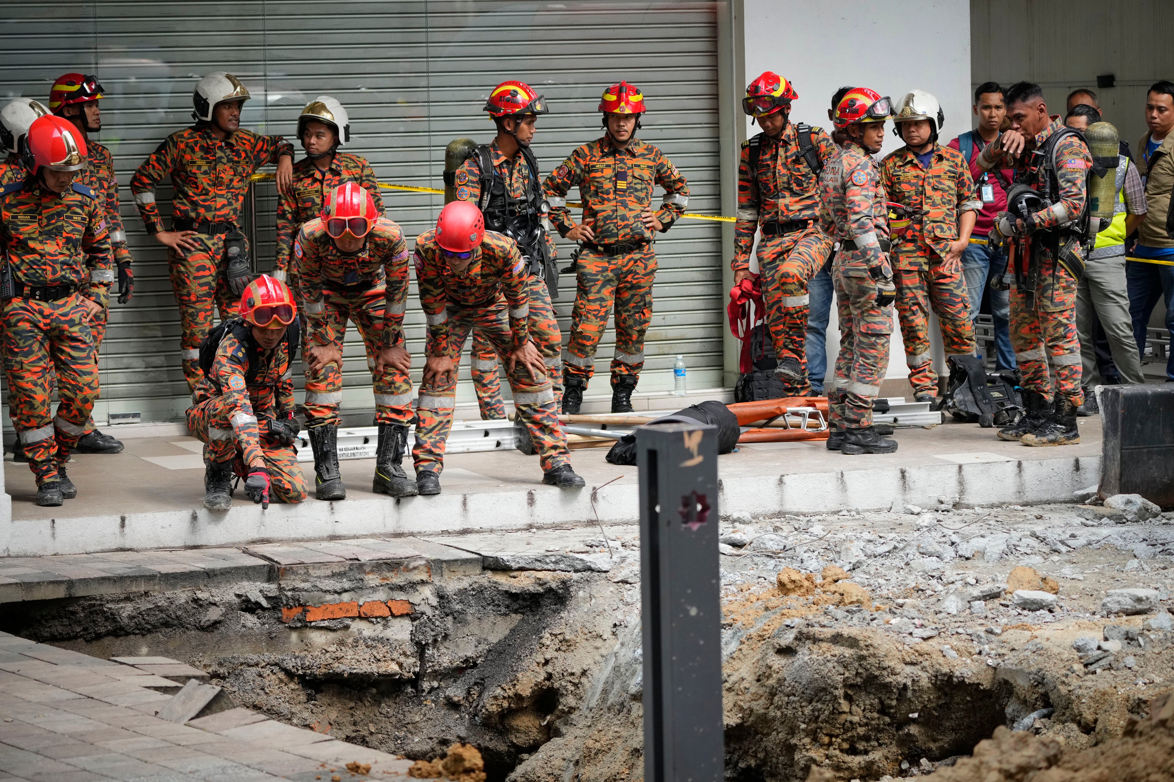 Rescuers check the sinkhole that opened up in Kuala Lumpur on August 23. Photo: AP