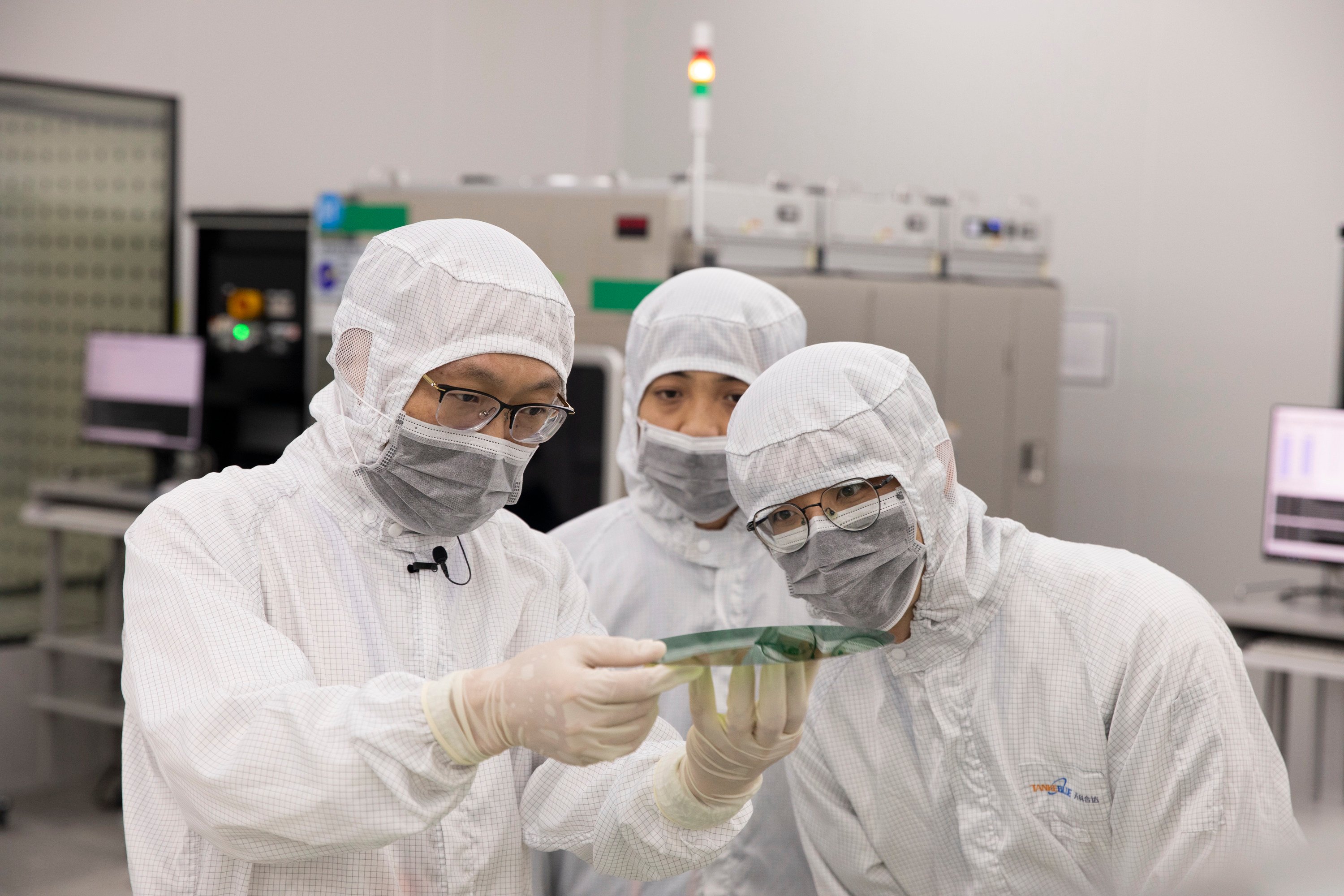 Workers inspect a semiconductor wafer at the headquarters of TankeBlue Semiconductor Company in Beijing on January 24. Photo: Xinhua