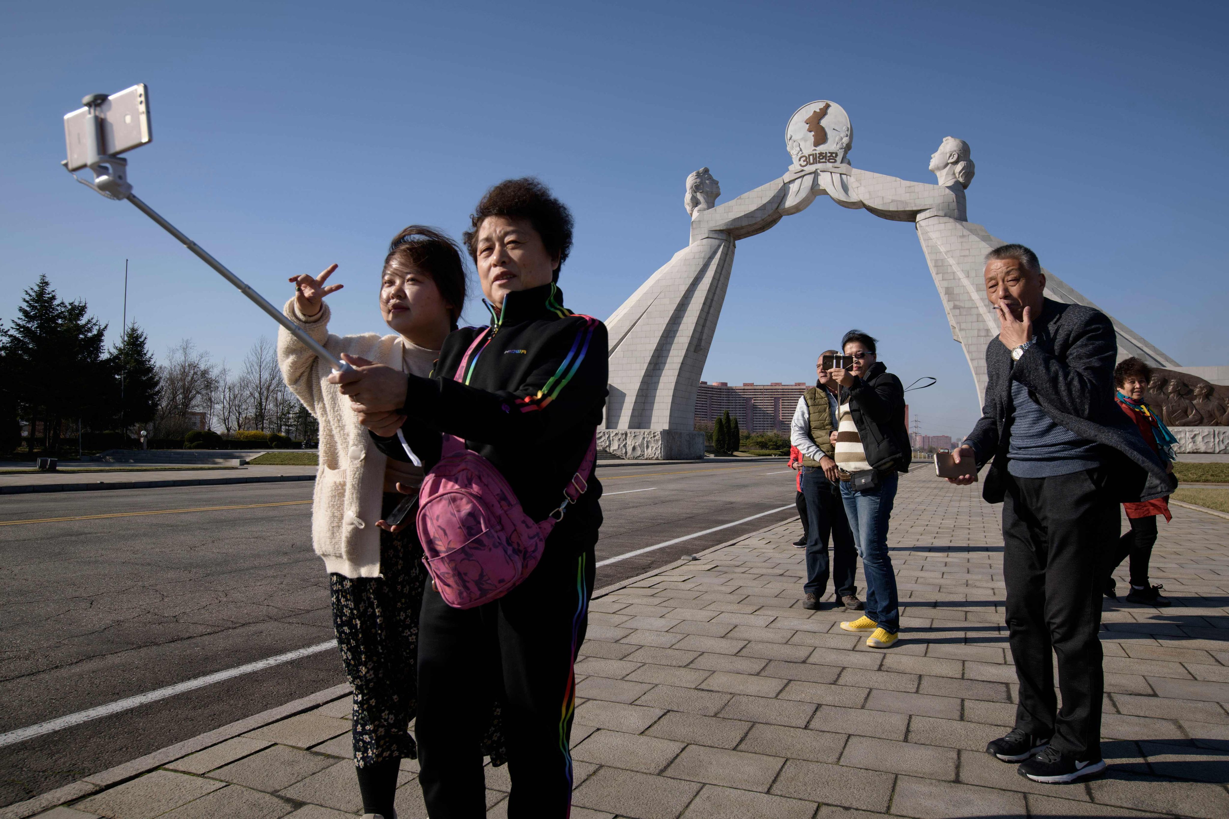 Tourists from China pose for photos before the Three Charters monument in Pyongyang in 2019. Photo: AFP