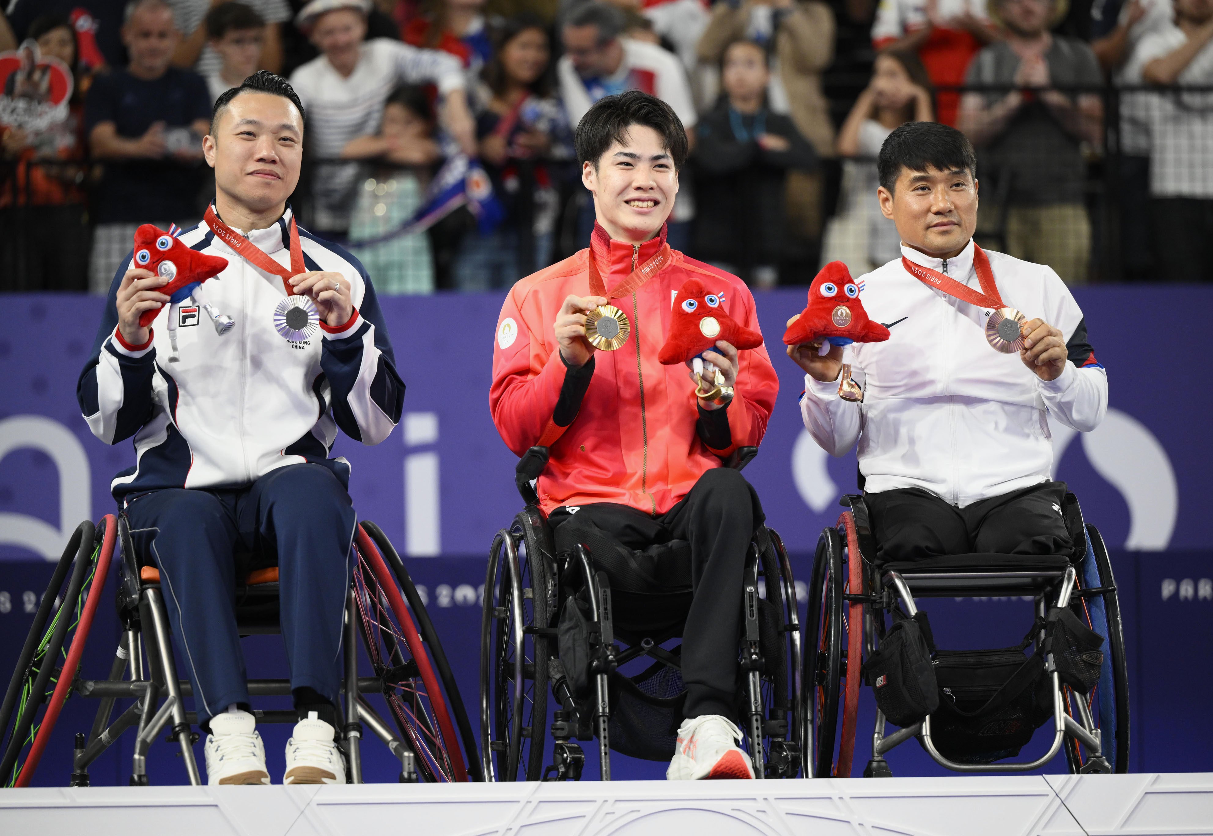 Silver medallist Chan Ho-yuen of Hong Kong, gold medallist Daiki Kajiwara of Japan and bronze medallist Kim Jung-jun of South Korea on the podium after the wheelchair badminton WH2 singles on Monday. Photo: Kyodo