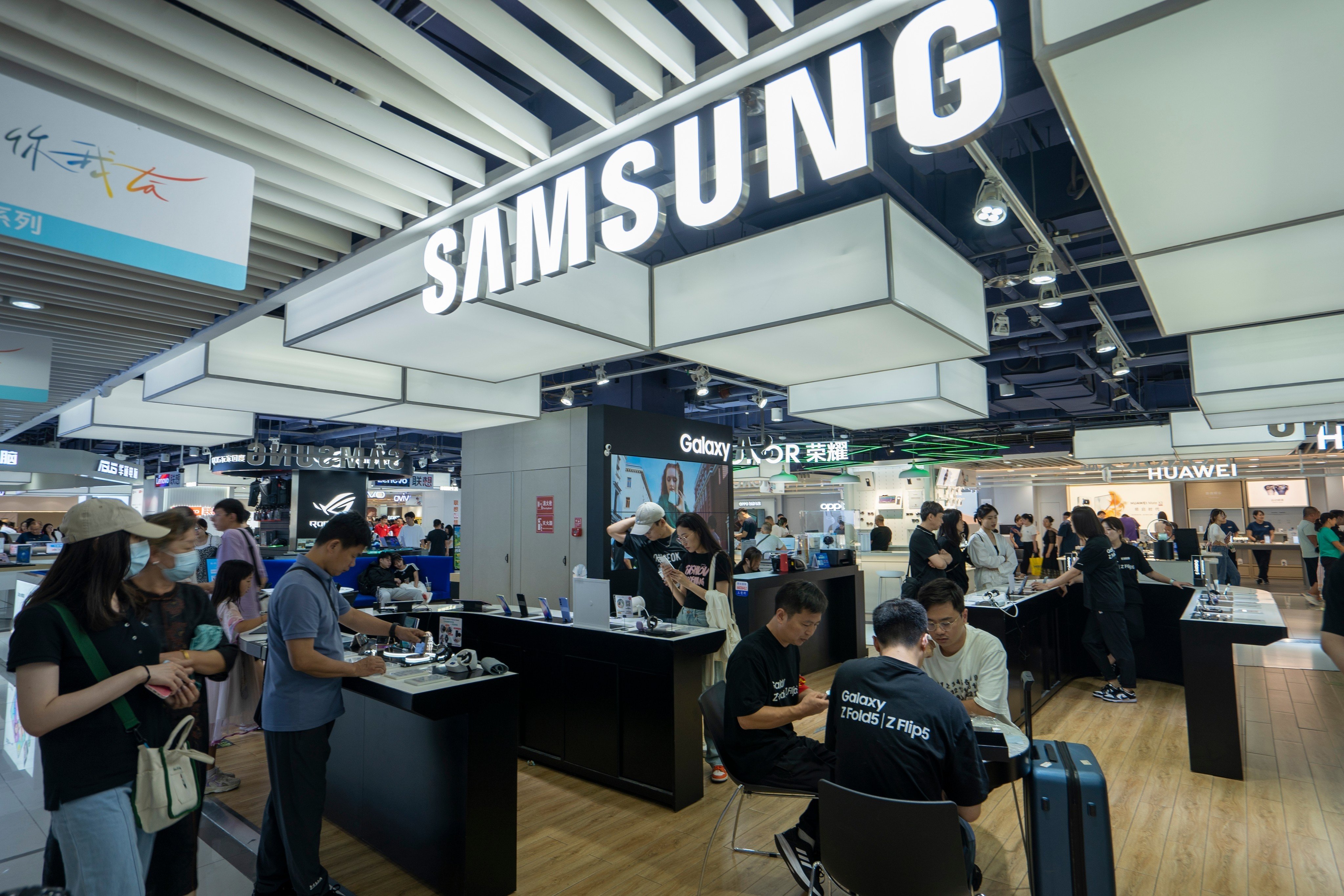 Shoppers at a Samsung Electronics store, next to other smartphone retailers,  inside the Xidan Joy City Shopping Centre in Beijing. Photo: Shutterstock