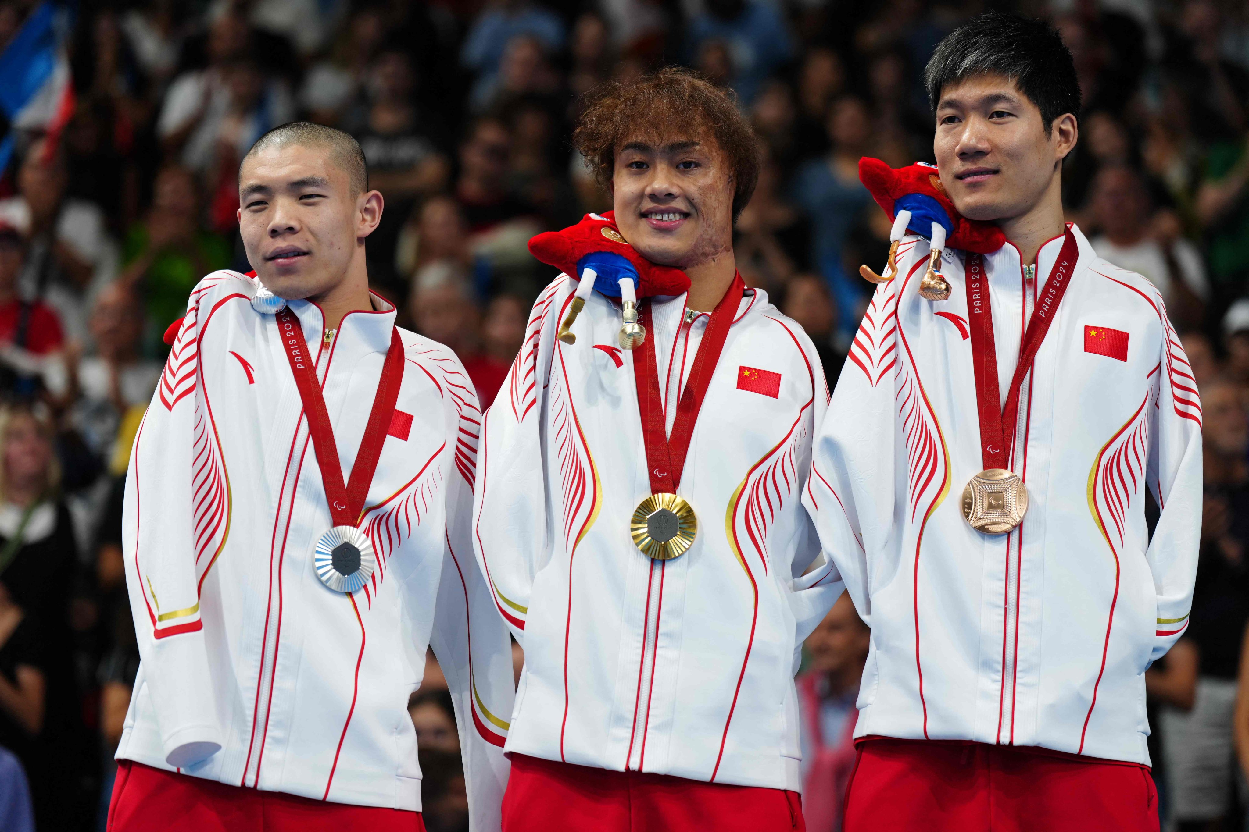 China’s (from left) silver medallist Guo Jincheng, gold medallist Yuan Weiyi and bronze medallist Wang Lichao after the men’s S5 50m backstroke final. Photo: AFP