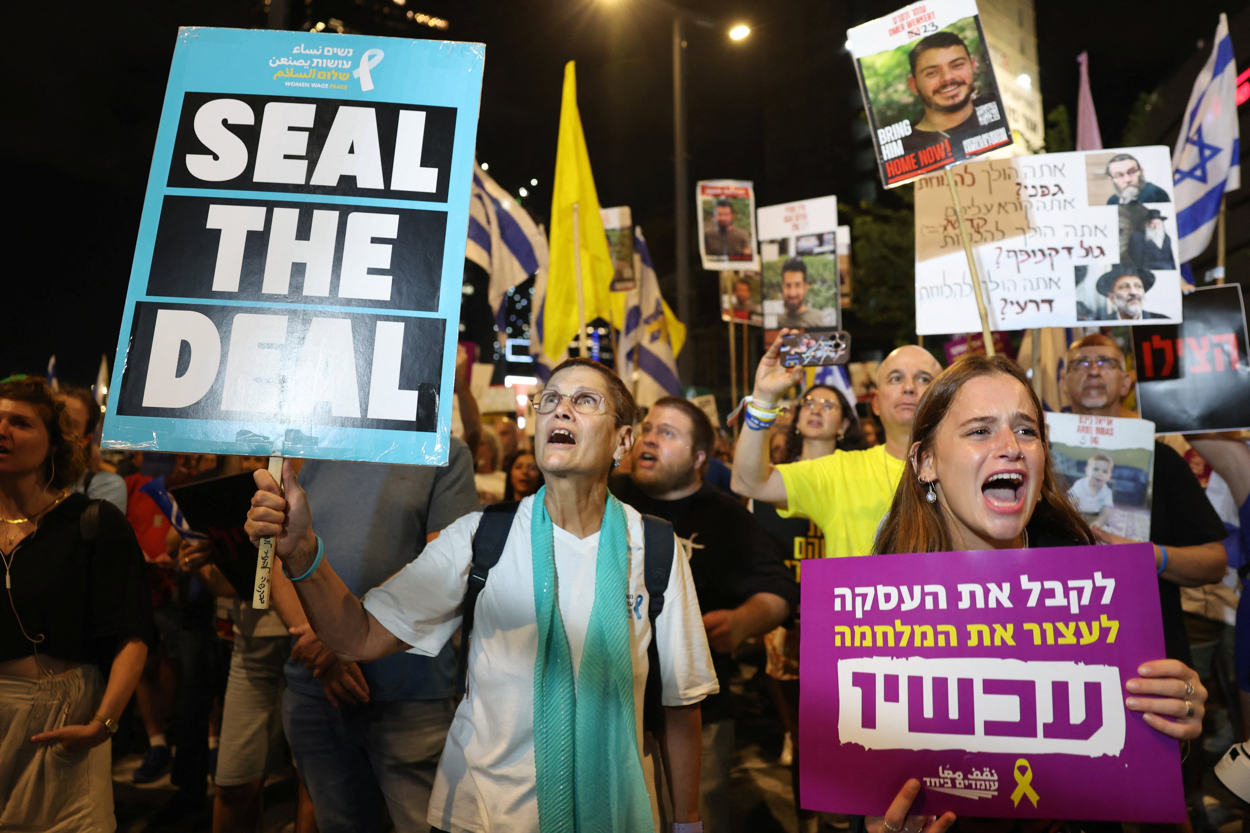 People hold placards as they protest against the government and to show support for hostages in Tel Aviv, Israel, on Tuesday. Photo: Reuters