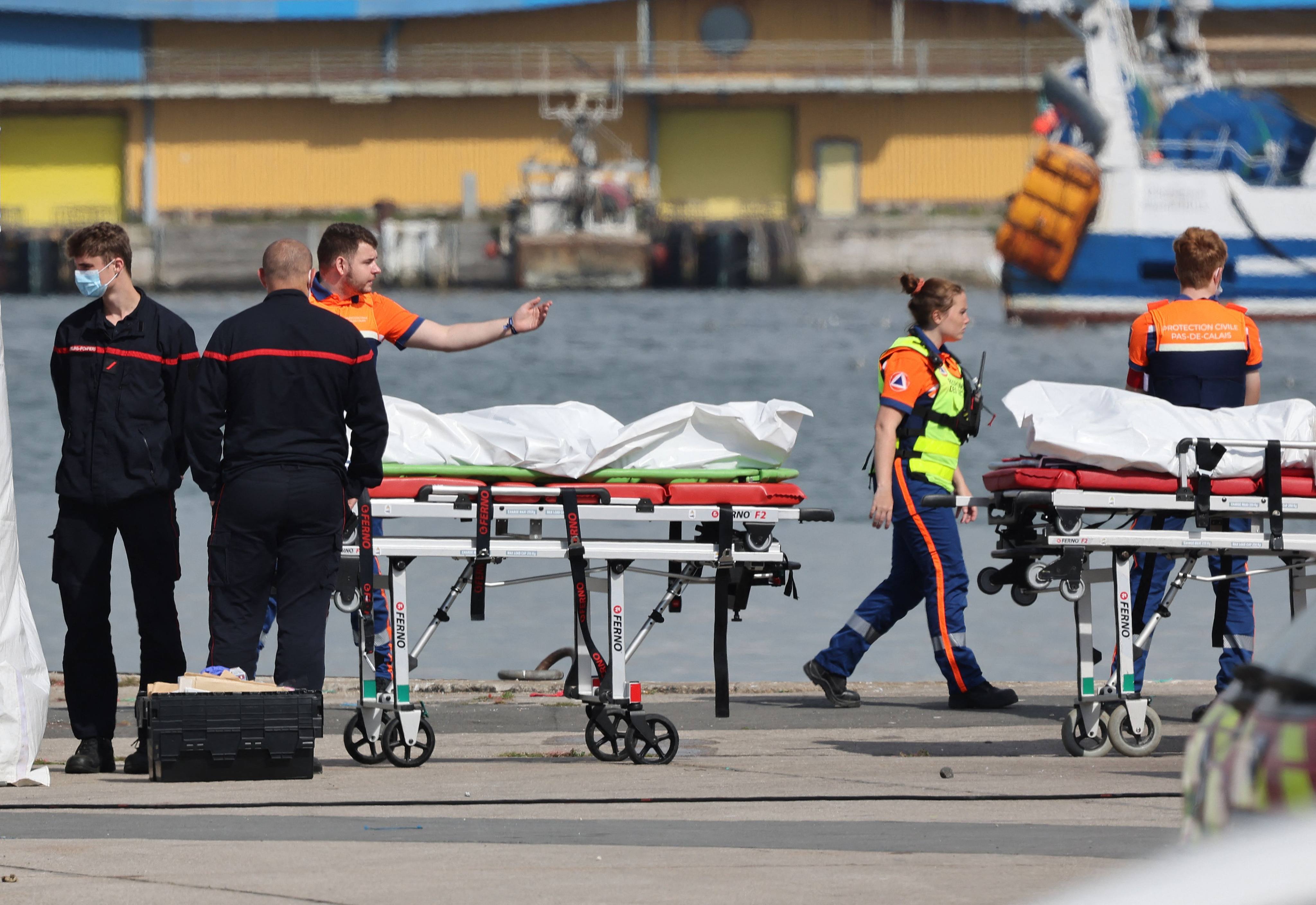 Firefighters and Civil Protection agents stand next to bags containing the bodies of migrants who died after the sinking of a migrant boat attempting to cross the Channel to England, in Boulogne-sur-Mer, northern France, on Saturday. Photo: AFP