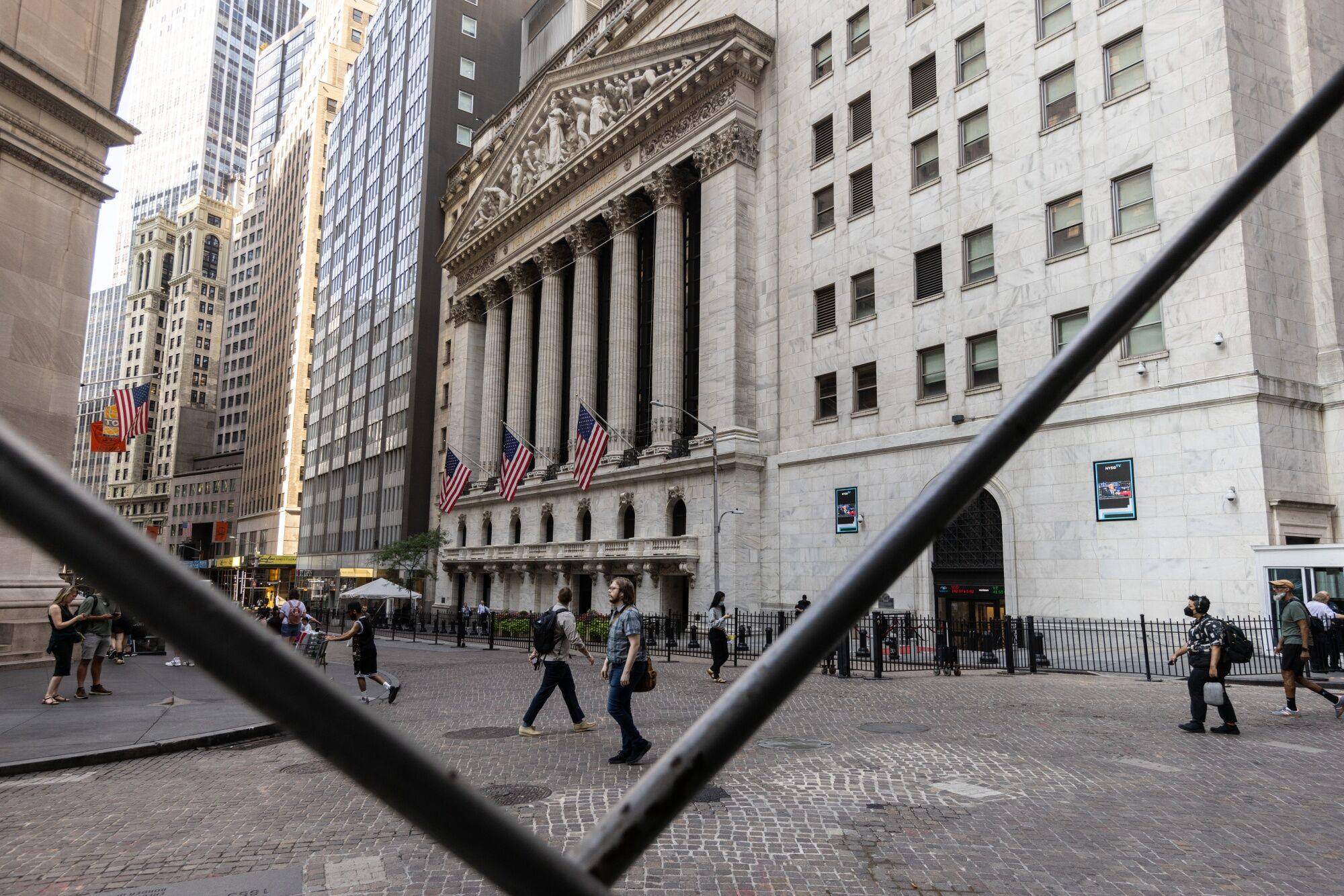 Pedestrians walk along Wall Street near the New York Stock Exchange on August 27.Talking about a Fed rate cut has been a psychological crutch for asset markets for two years. Photo: Bloomberg 
