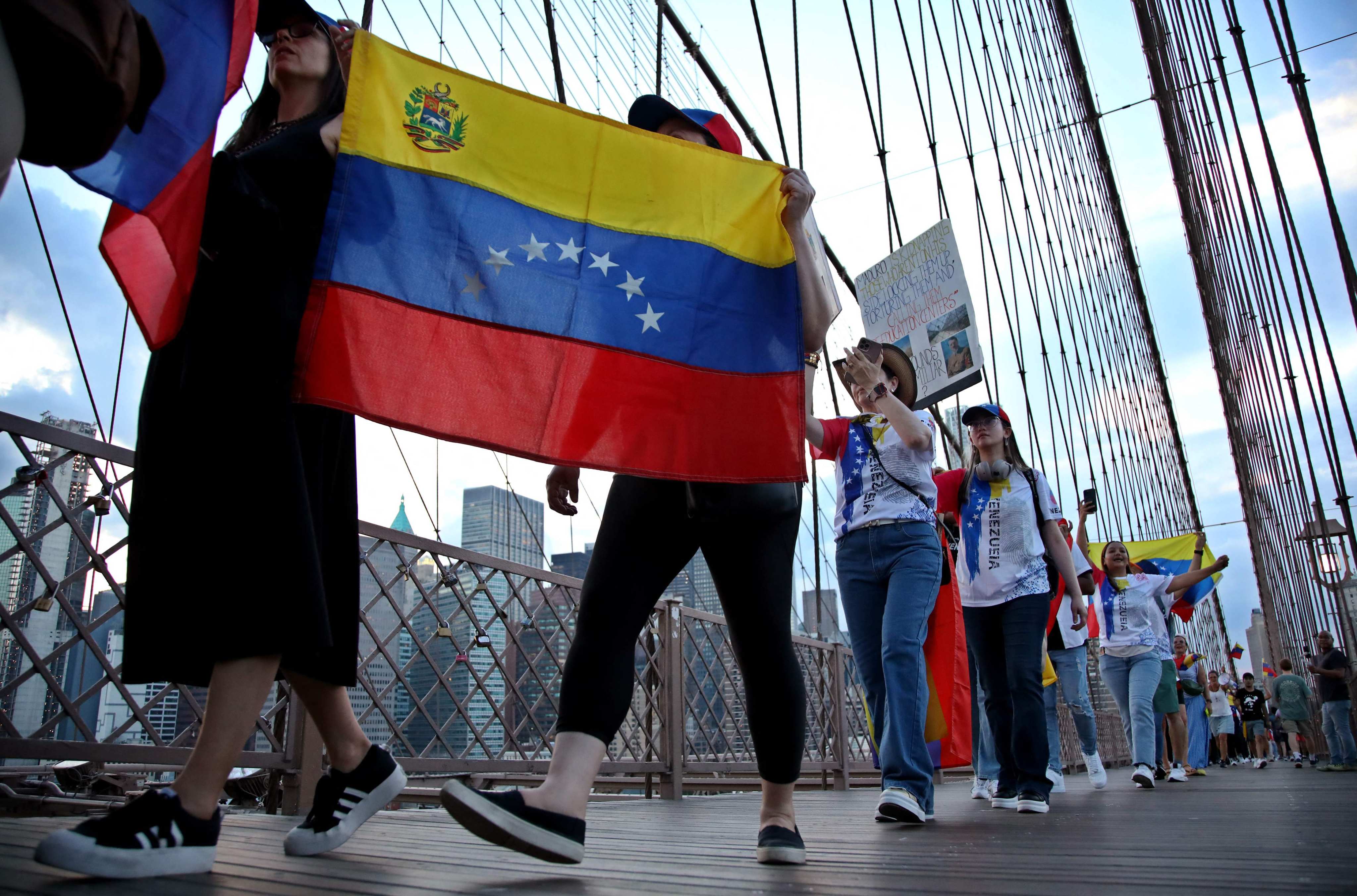 People hold Venezuelan flags as they protest against President Nicolas Maduro and the results of the recent election on the Brooklyn Bridge in New York in August. Photo: AFP