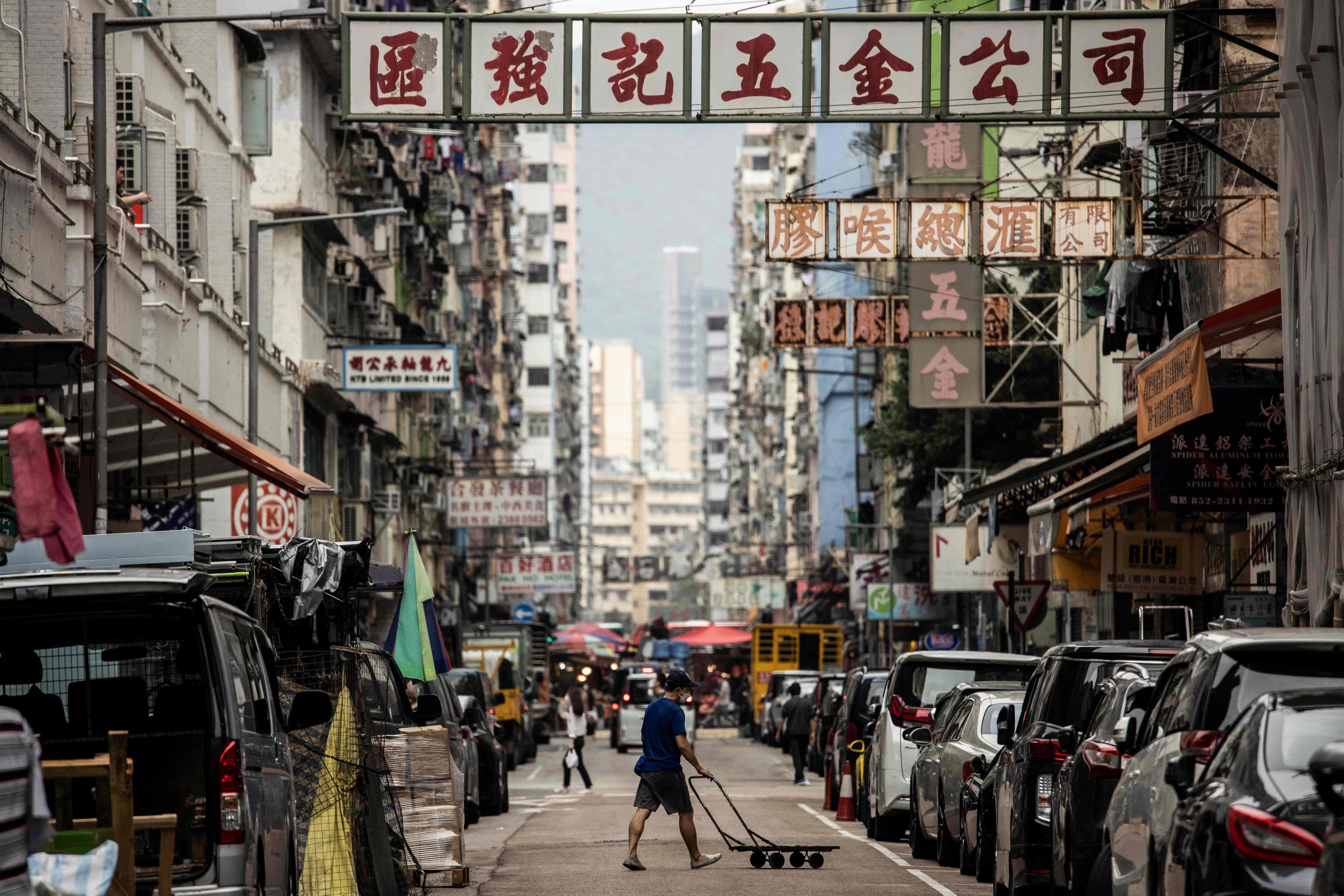 A man pushes a trolly across a street in the Kowloon on November 22, 2022. Two K-pop videos set in Hong Kong show how the city’s grittier side might be attractive to people around the world. Photo: AFP