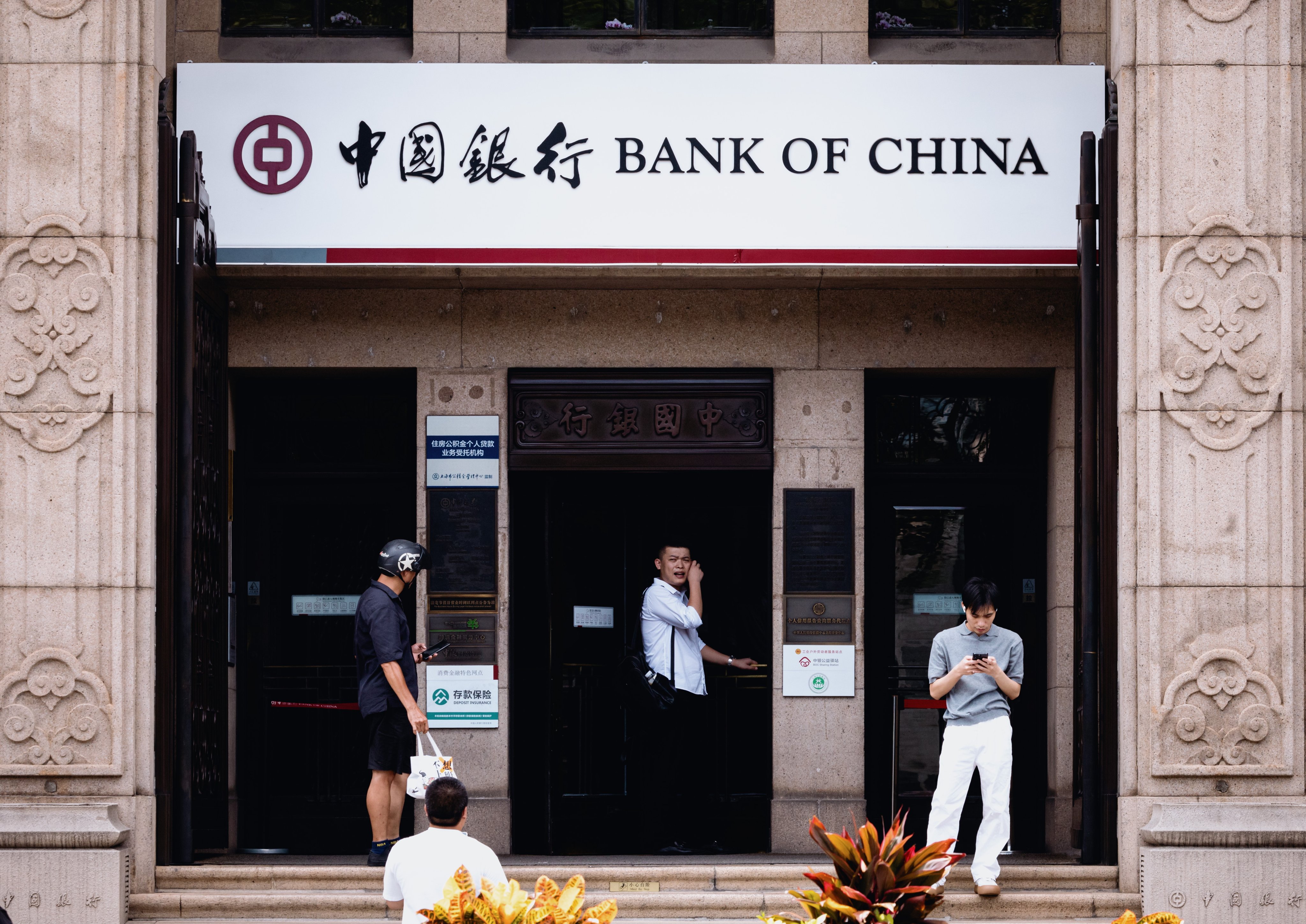 People stand in front of a Bank of China branch in Shanghai. Photo: EPA-EFE