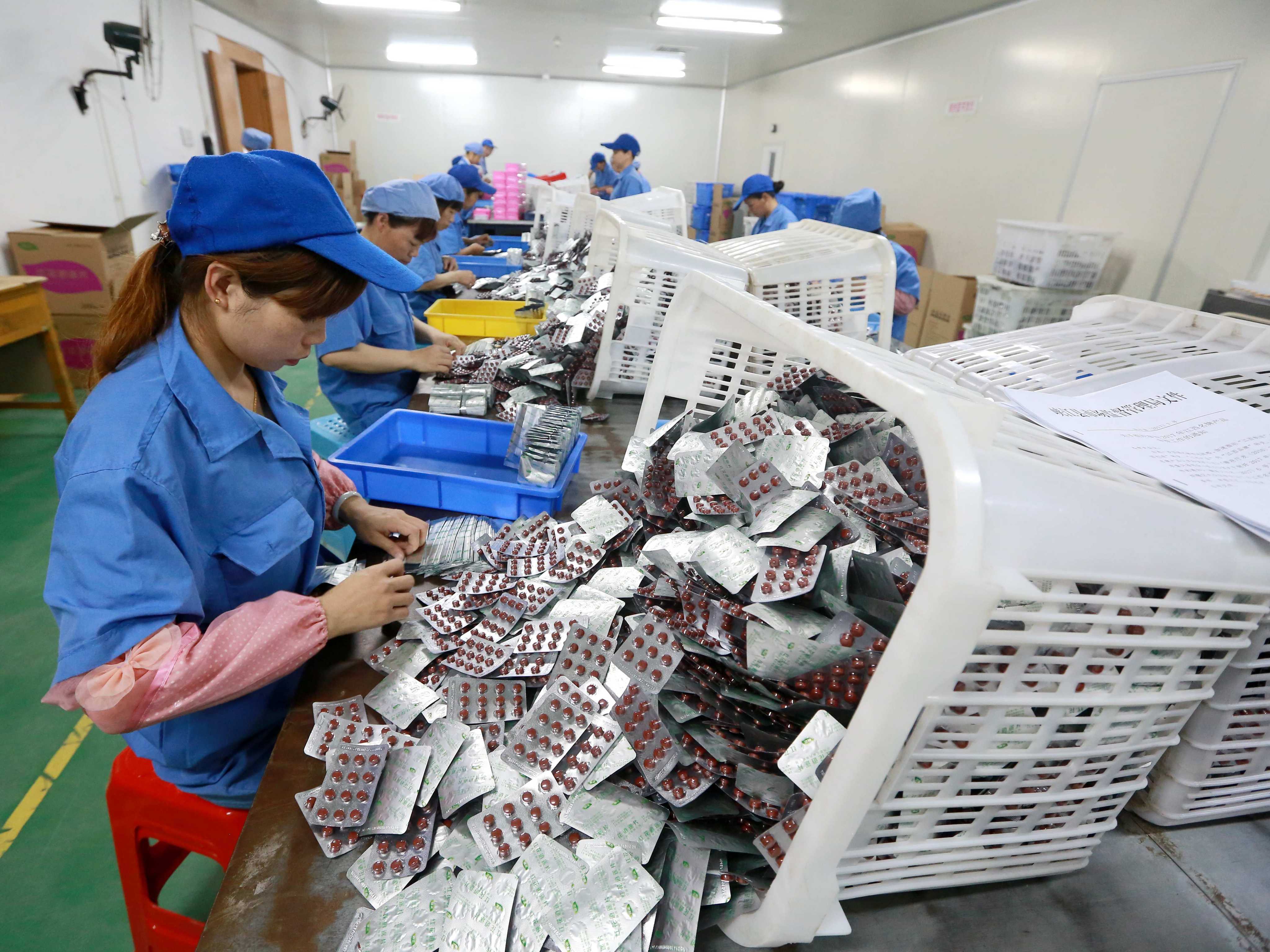 Chinese workers produce medicines at a factory in Xiajiang county. Photo: Imaginechina via AFP