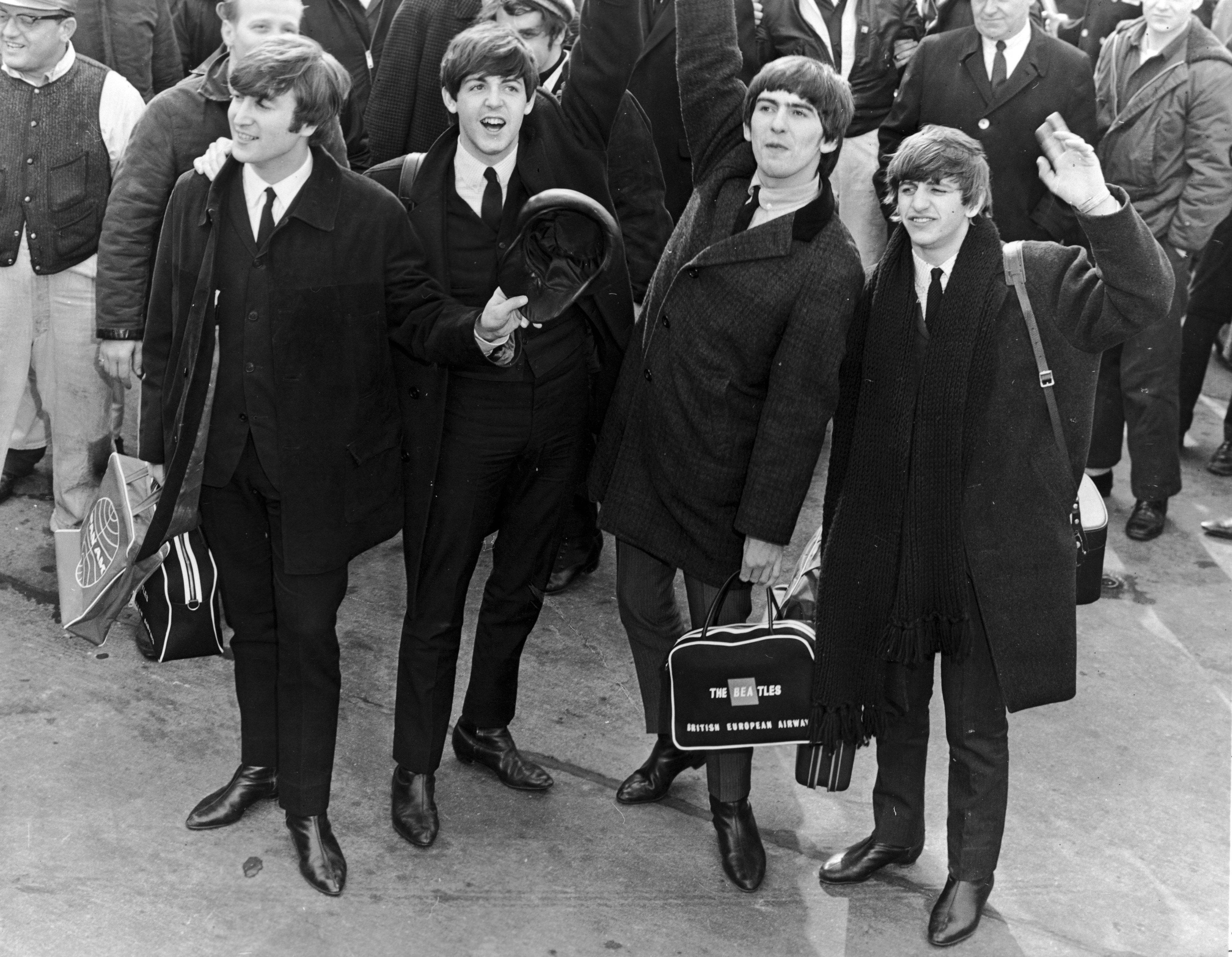 The Beatles wave to a crowd as they arrive in the United States for their 1964 North American tour. Photo: Getty Images