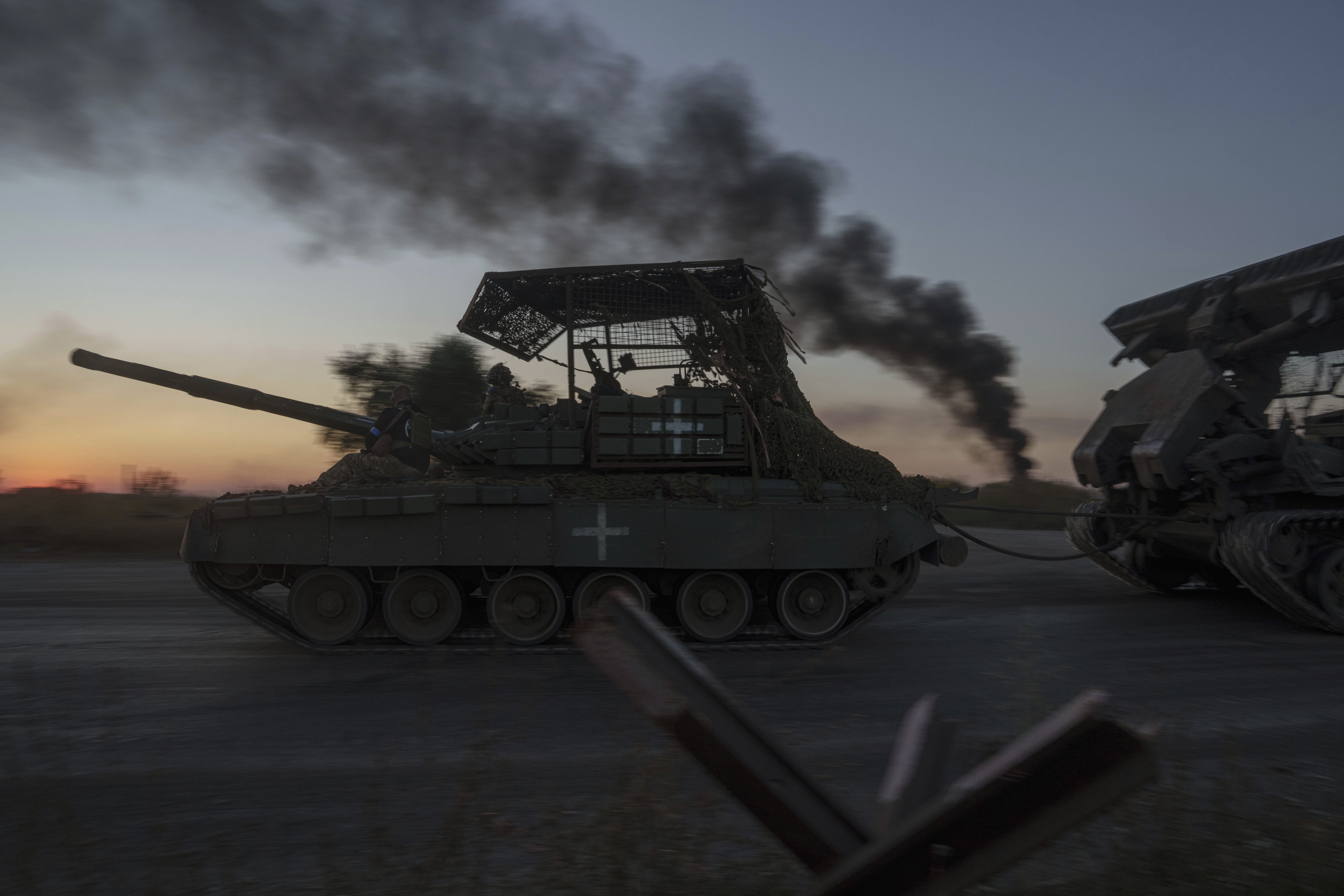 Ukrainian servicemen ride atop a tank after returning from the Sumy region near the border with Russia on August 17. Photo: AP