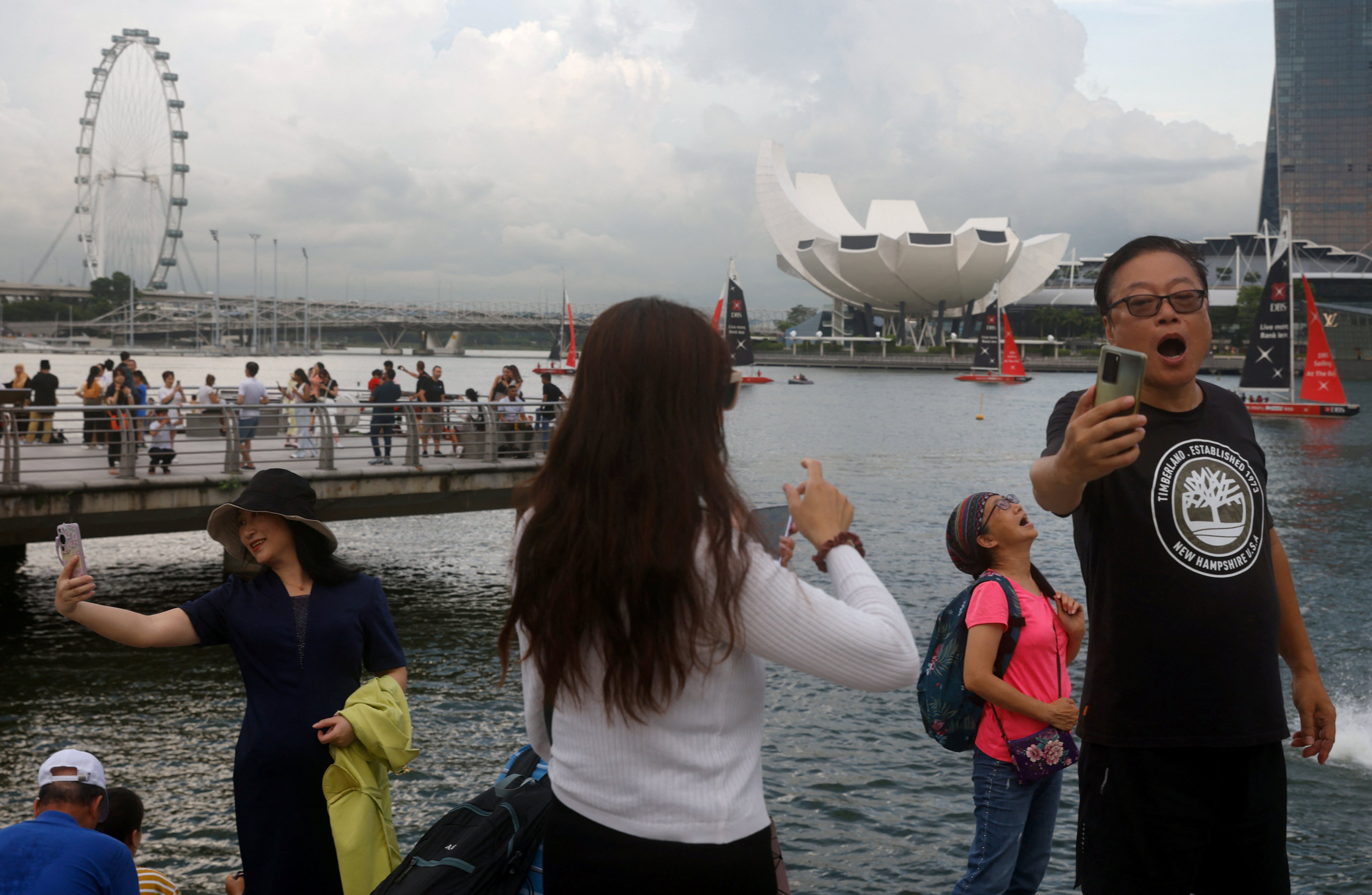 Chinese tourists pose for photos with the Merlion statue at Marina Bay in Singapore in May 2023. Photo: Reuters
