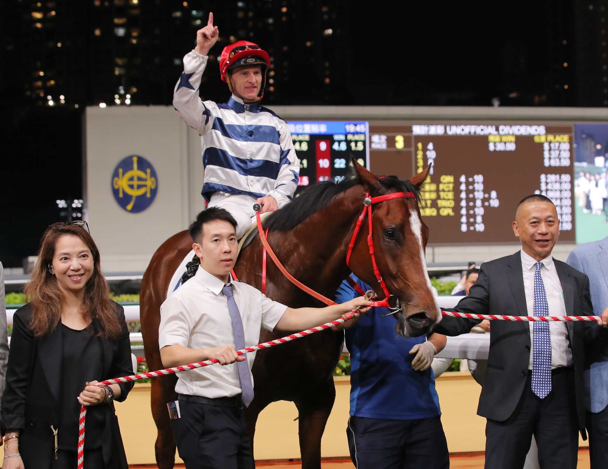 Trainer Danny Shum (right), jockey Zac Purton and connections of Packing Power celebrate his debut win.