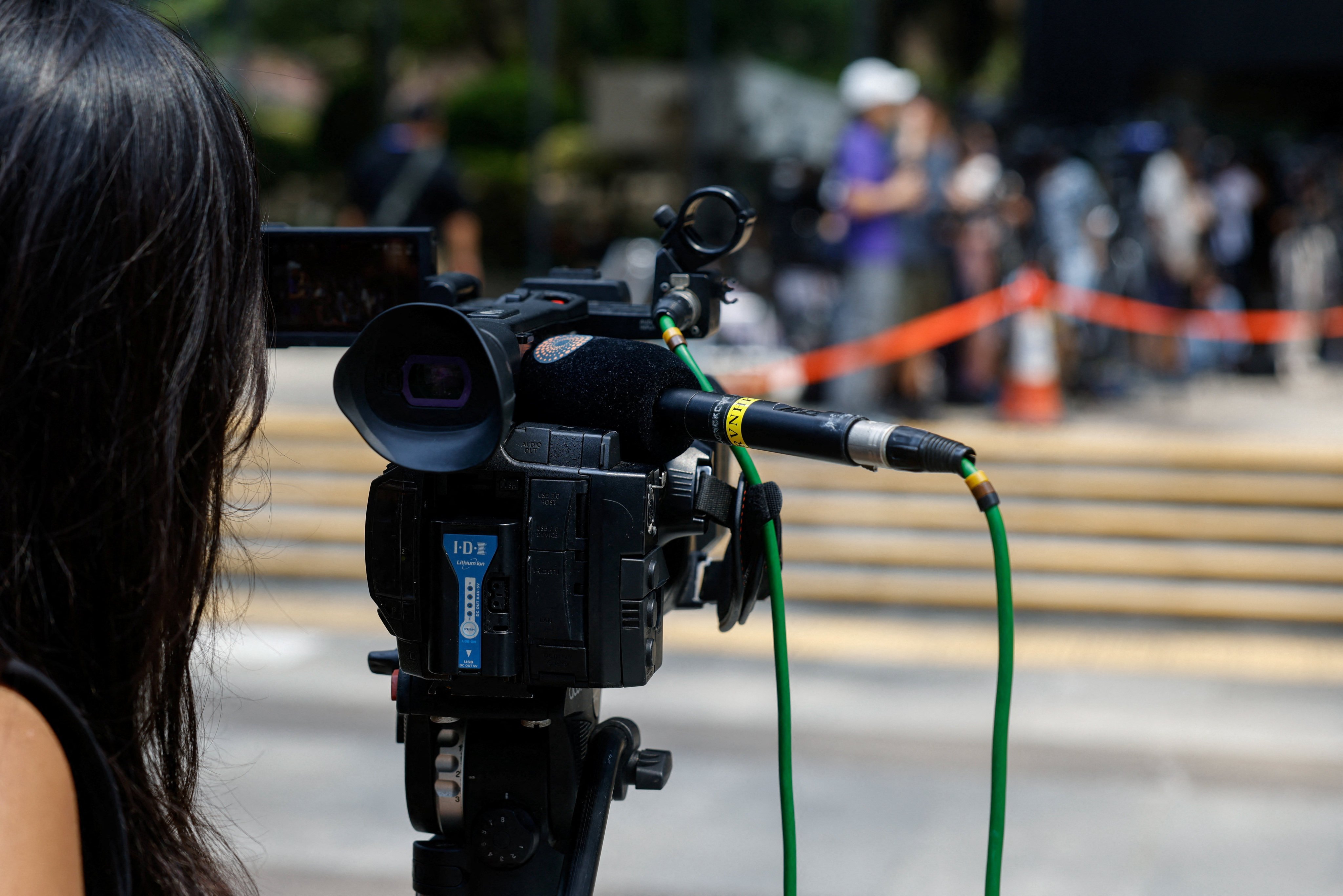 A member of the media works outside Hong Kong’s District Court in Wan Chai ahead of the verdict in a landmark sedition trial against the now-closed online media outlet Stand News, on August 29. Photo: Reuters 