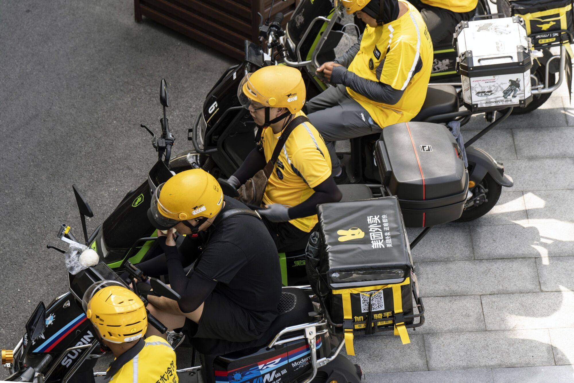 Food delivery couriers for Meituan in Shanghai, China. Photo: Bloomberg