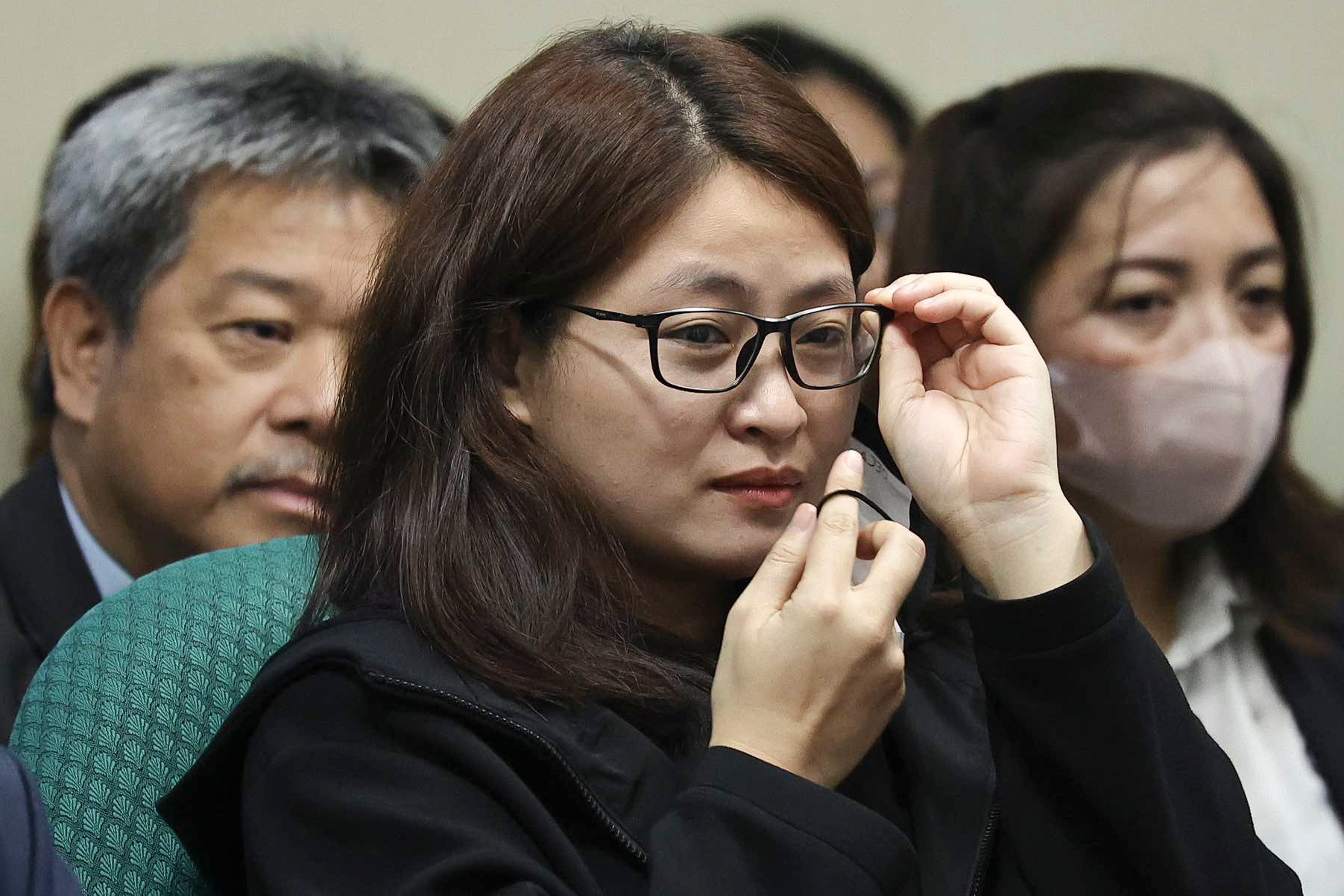 Dismissed Bamban Mayor Alice Guo, a fugitive recently arrested in Indonesia, holds her glasses during a Senate hearing on Monday. Photo: Philippine Senate Social Media Unit via AP