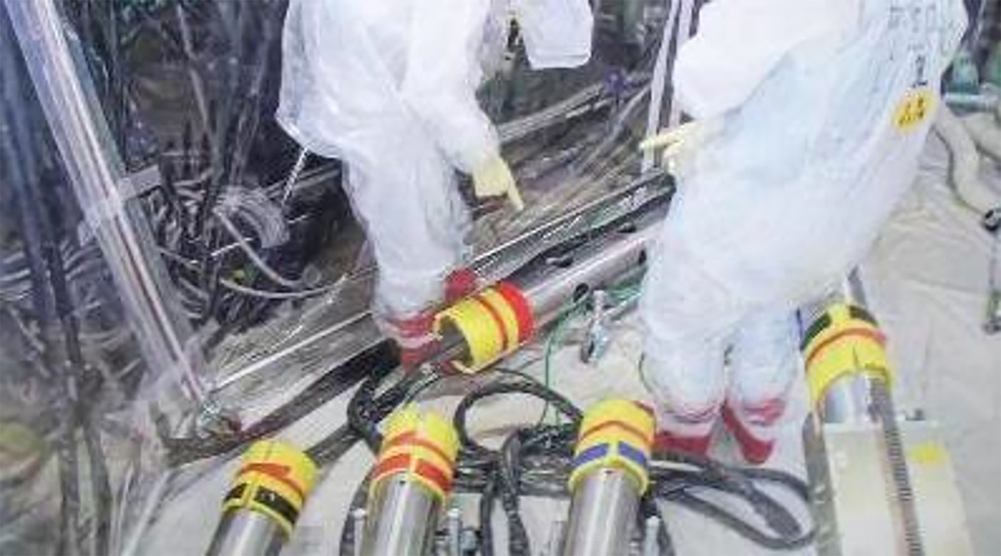 Tepco workers rearrange pipes for the recovery mission at Fukjushima Daiichi nuclear power plant. Photo: Tokyo Electric Power Company Holdings via AP