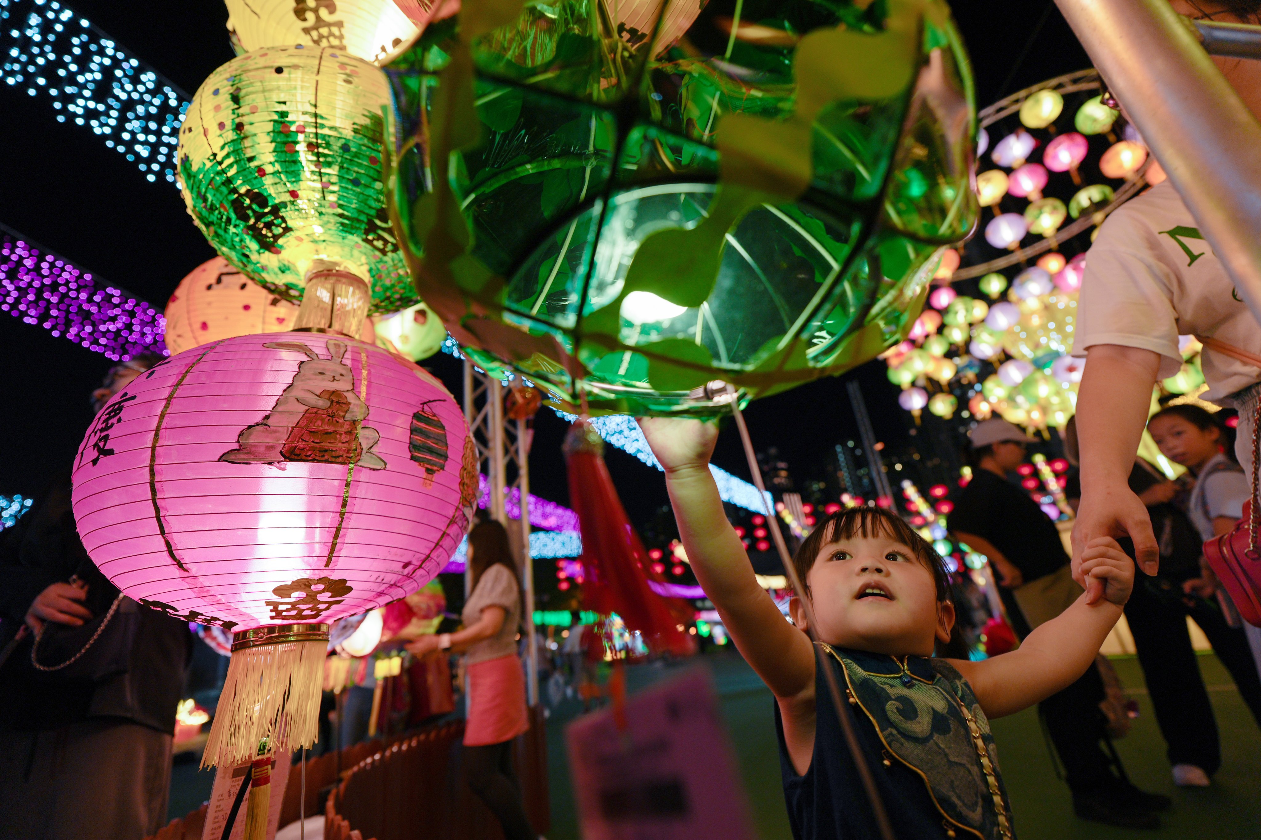 The lanterns in Victoria Park are a colourful draw for this child. Photo: Eugene Lee