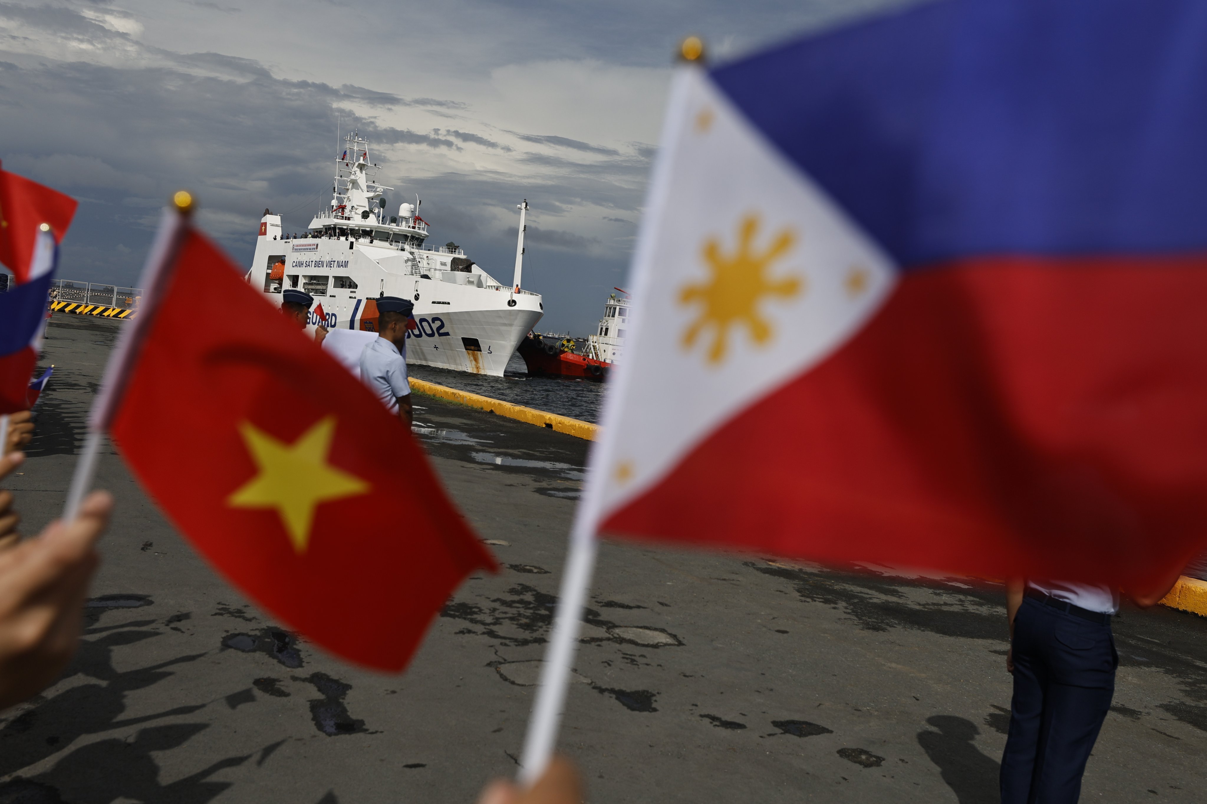 Philippine Coast Guard personnel wave flags as a Vietnam Coast Guard patrol ship makes a port call at the Port of Manila on August 5. Photo: EPA-EFE