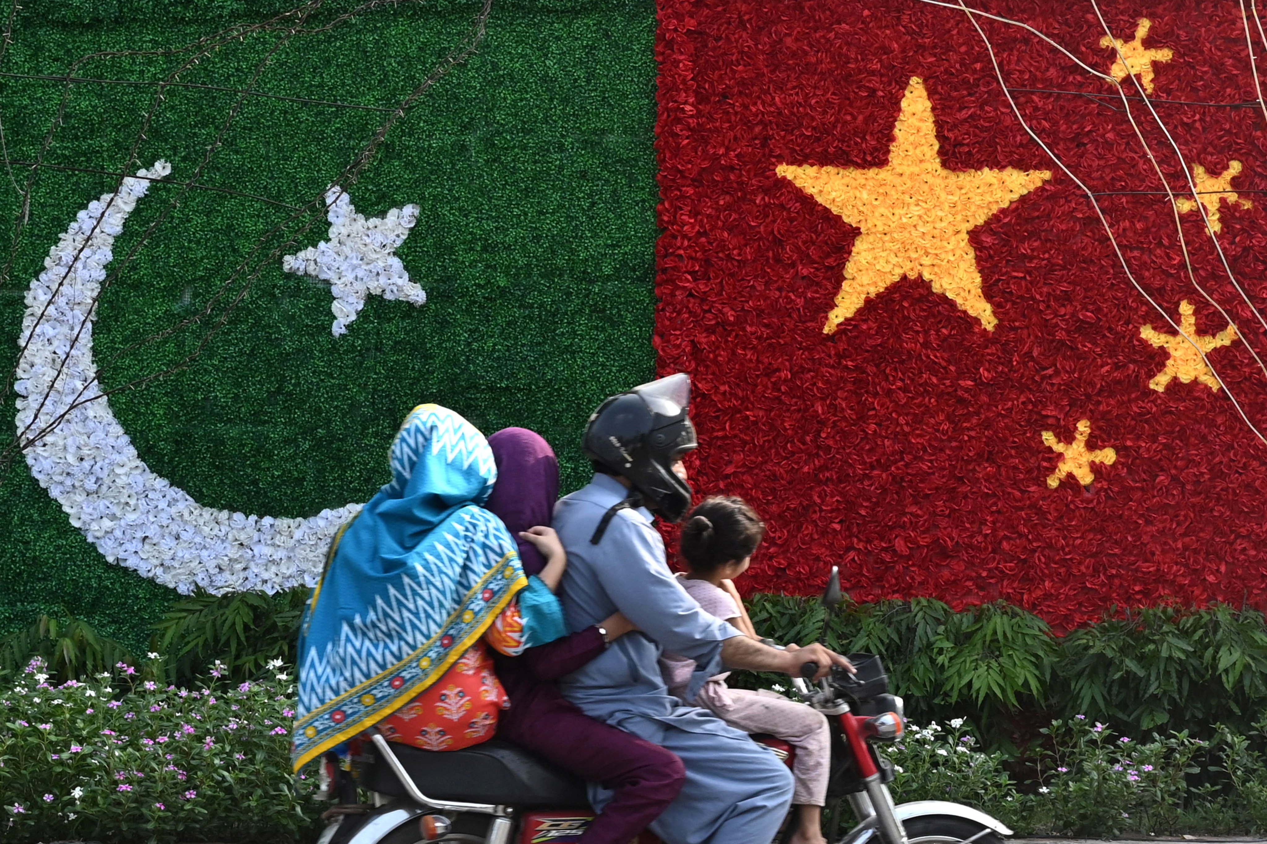 A family rides past a decoration in the shape of the national flags of China and Pakistan ahead of a visit to the capital city of Lahore by Chinese Vice-Premier He Lifeng in July last year to mark the 10th anniversary of a mega economic plan that is the cornerstone of Beijing’s Belt and Road Initiative. Photo: AFP