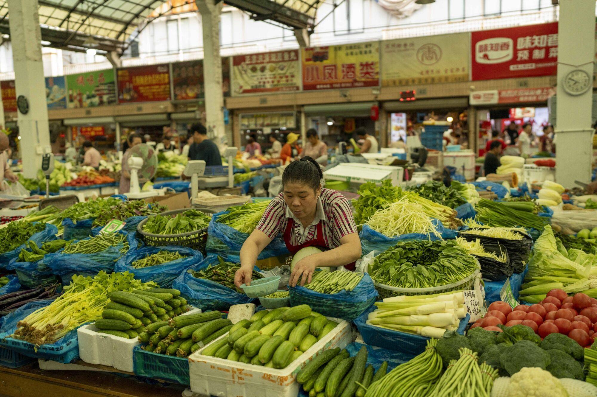 A vendor tends to produce at a fresh food market in Shanghai, China, on August 7, 2023. Photo: Bloomberg