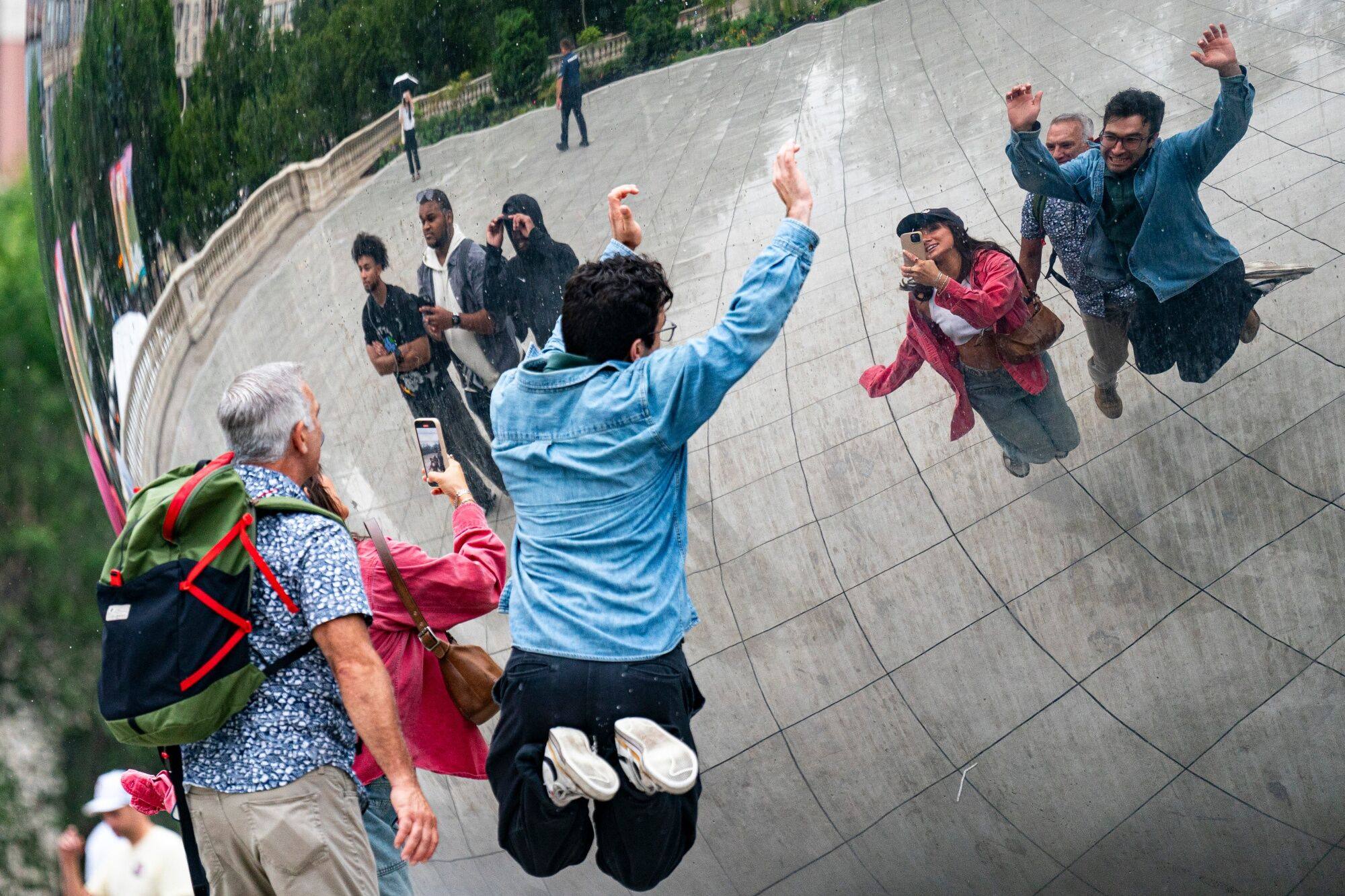 Visitors take photos in front of the Cloud Gate sculpture, known as the Bean, at Millennium Park in Chicago on August 15. The city of Chicago is delaying its US$643 million bond sale that was expected to price last week amid volatility in the US$4 trillion market for state and local bonds. Photo: Bloomberg