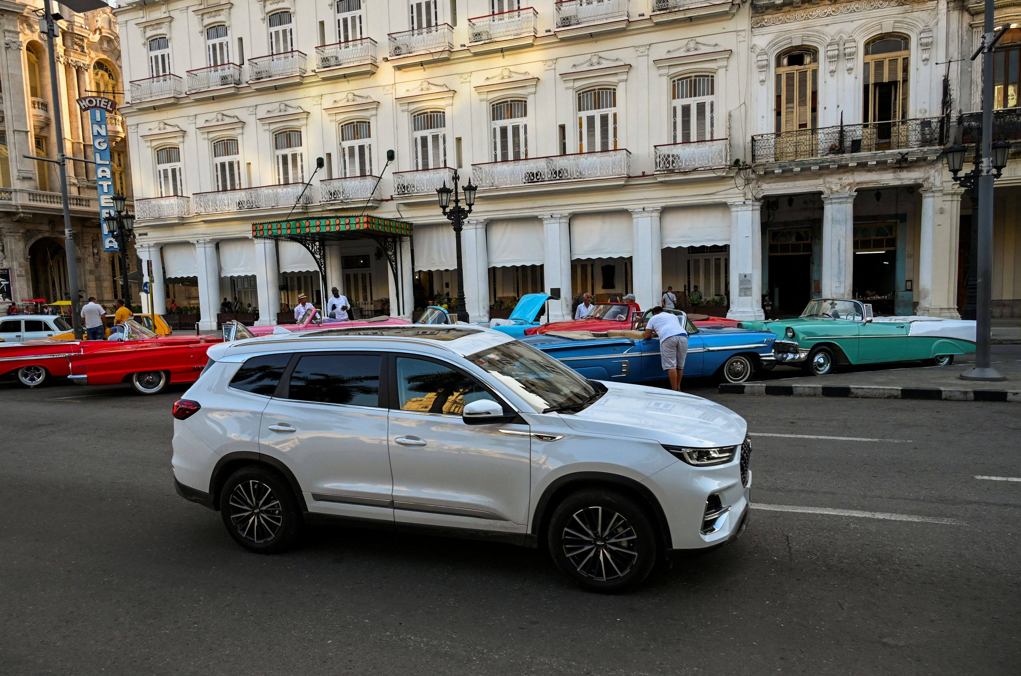 A Chery Tiggo 8 passes old American cars in Havana, Cuba. Photo: AFP