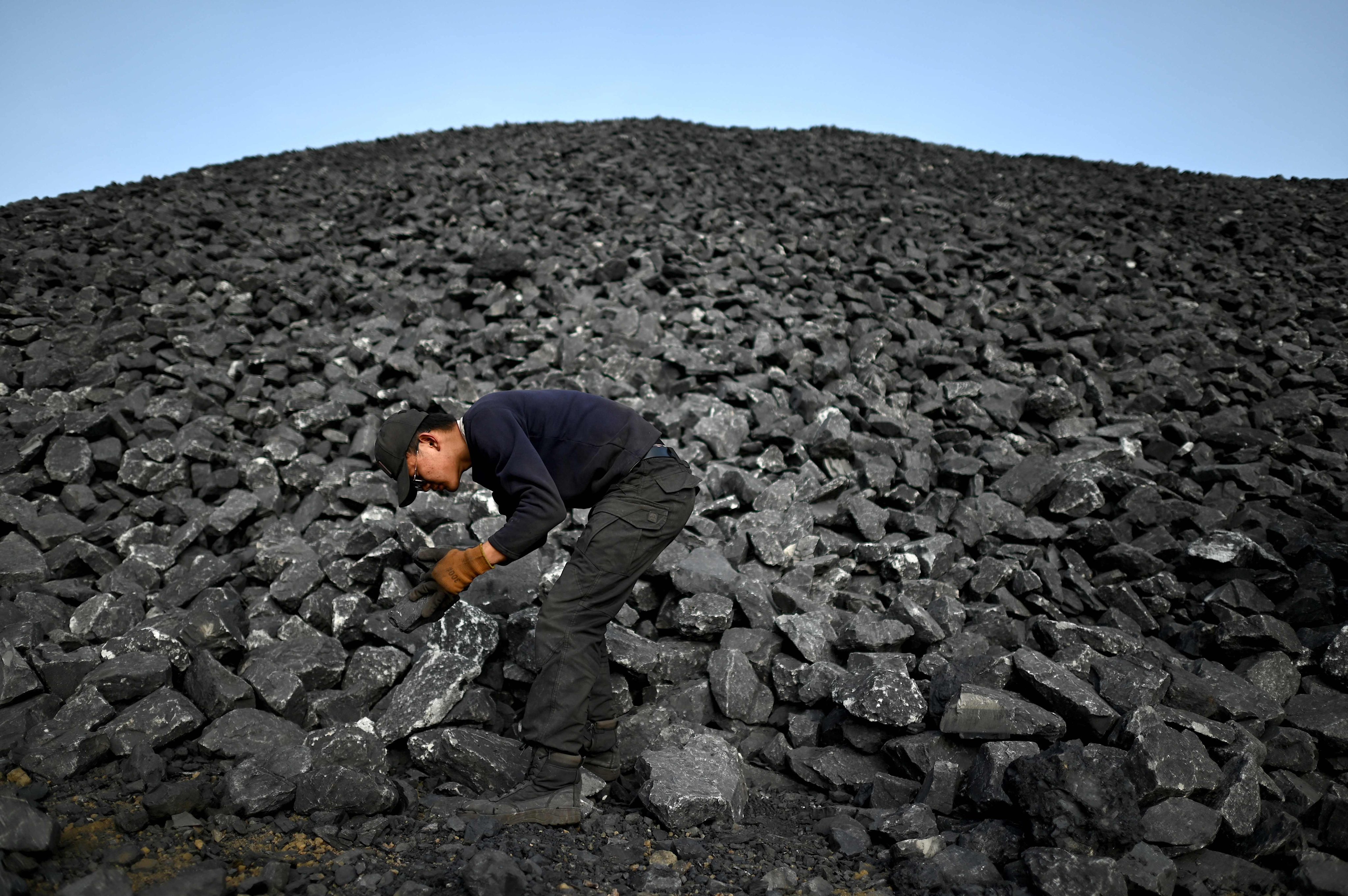 A worker sorts coal near a coal mine in Datong, in northern Shanxi province, in November 2021. China has made significant progress in lowering its carbon emissions, but that progress continues to be offset by the growth of the country’s coal sector. Photo: AFP