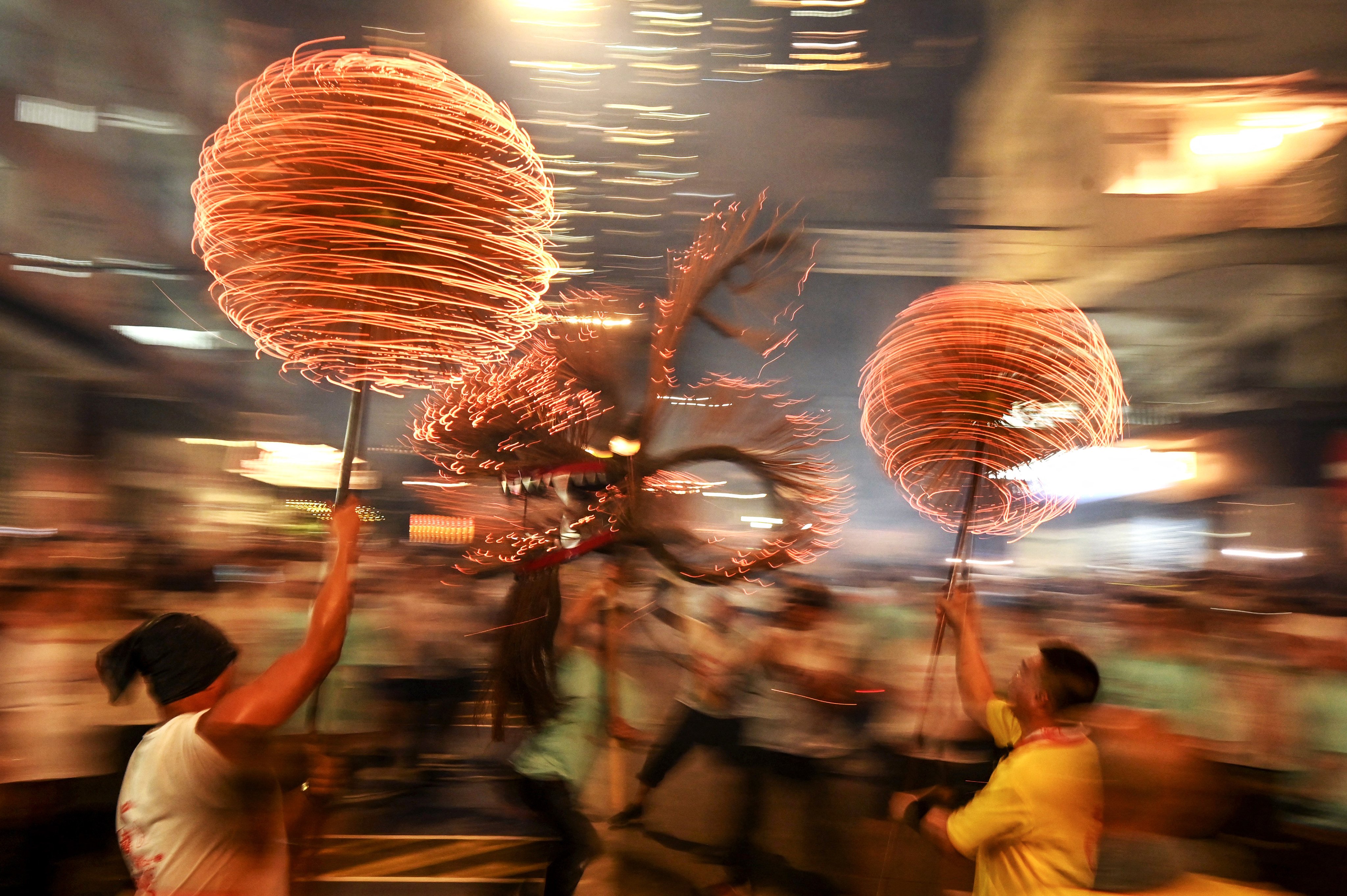 Members of the Tai Hang Fire Dragon Dance team spin balls of joss sticks as the “dragon” winds through Tai Hang on September 29, 2023. Photo: AFP