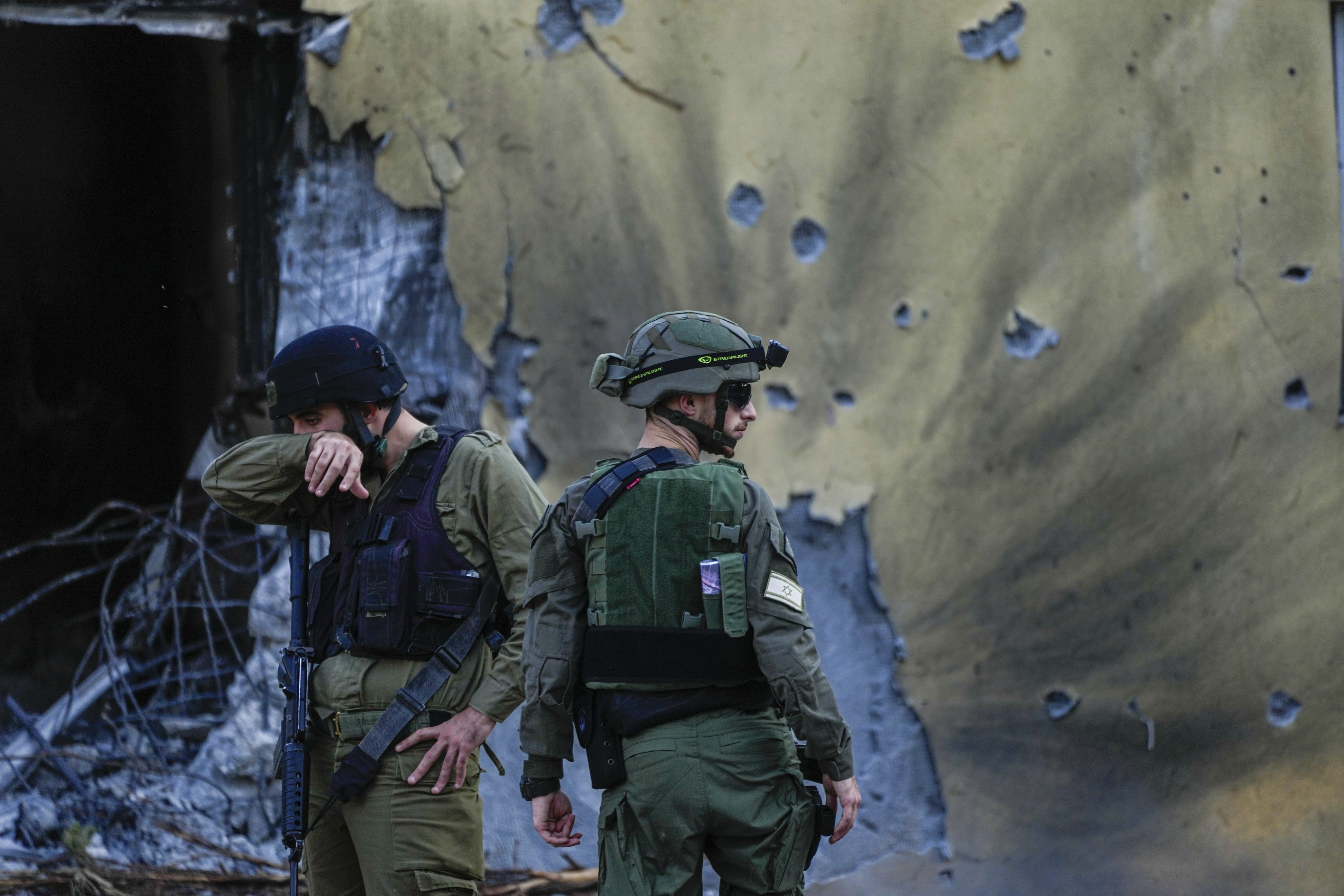 Israeli soldiers walk past houses destroyed by Hamas militants in Kibbutz Be’eri, Israel in October 2023. Photo: AP