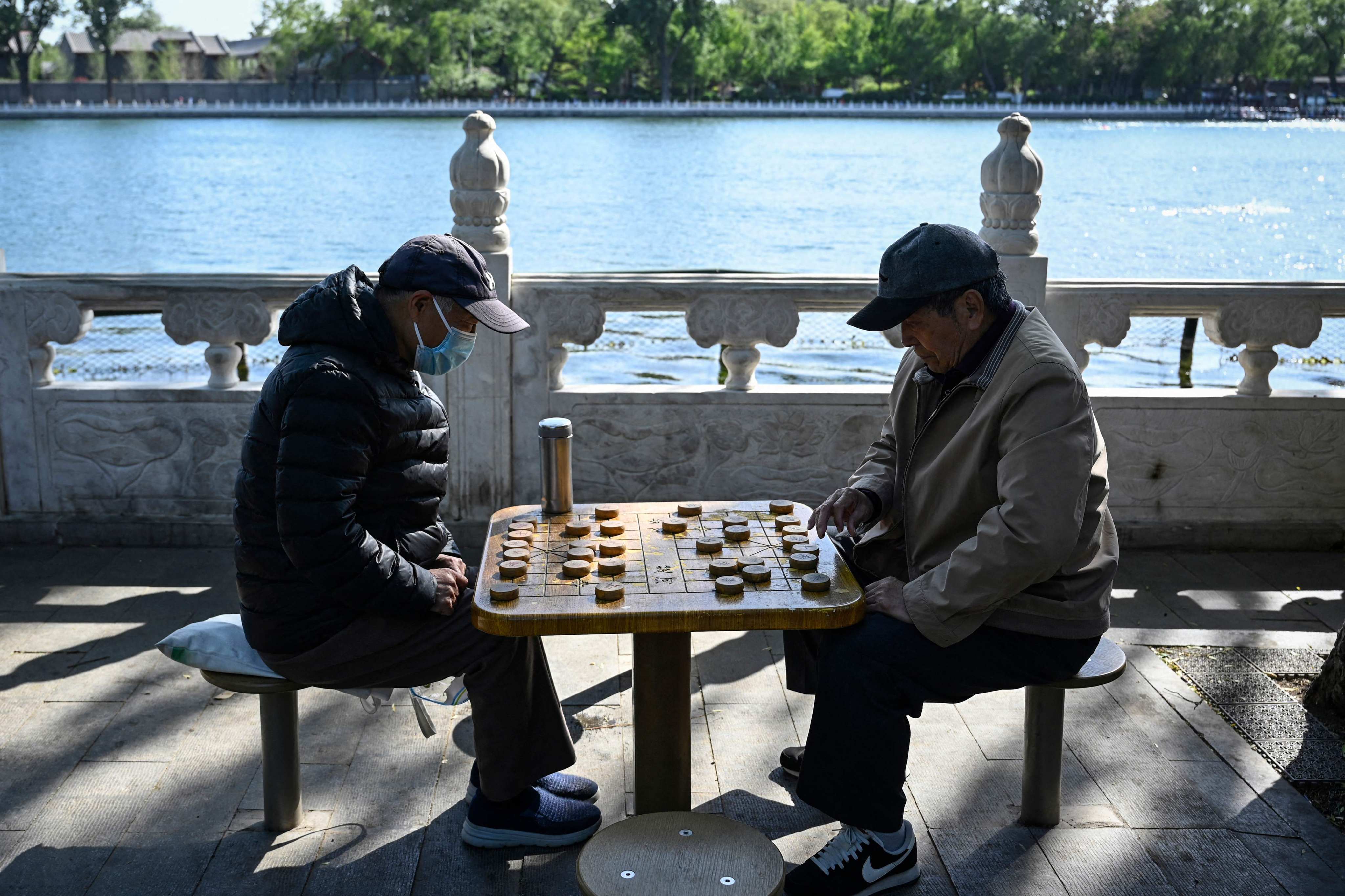 Two elderly men play Chinese chess at a park in Beijing. China’s top legislative body on Friday passed legislation to gradually lift the retirement age. Photo: AFP