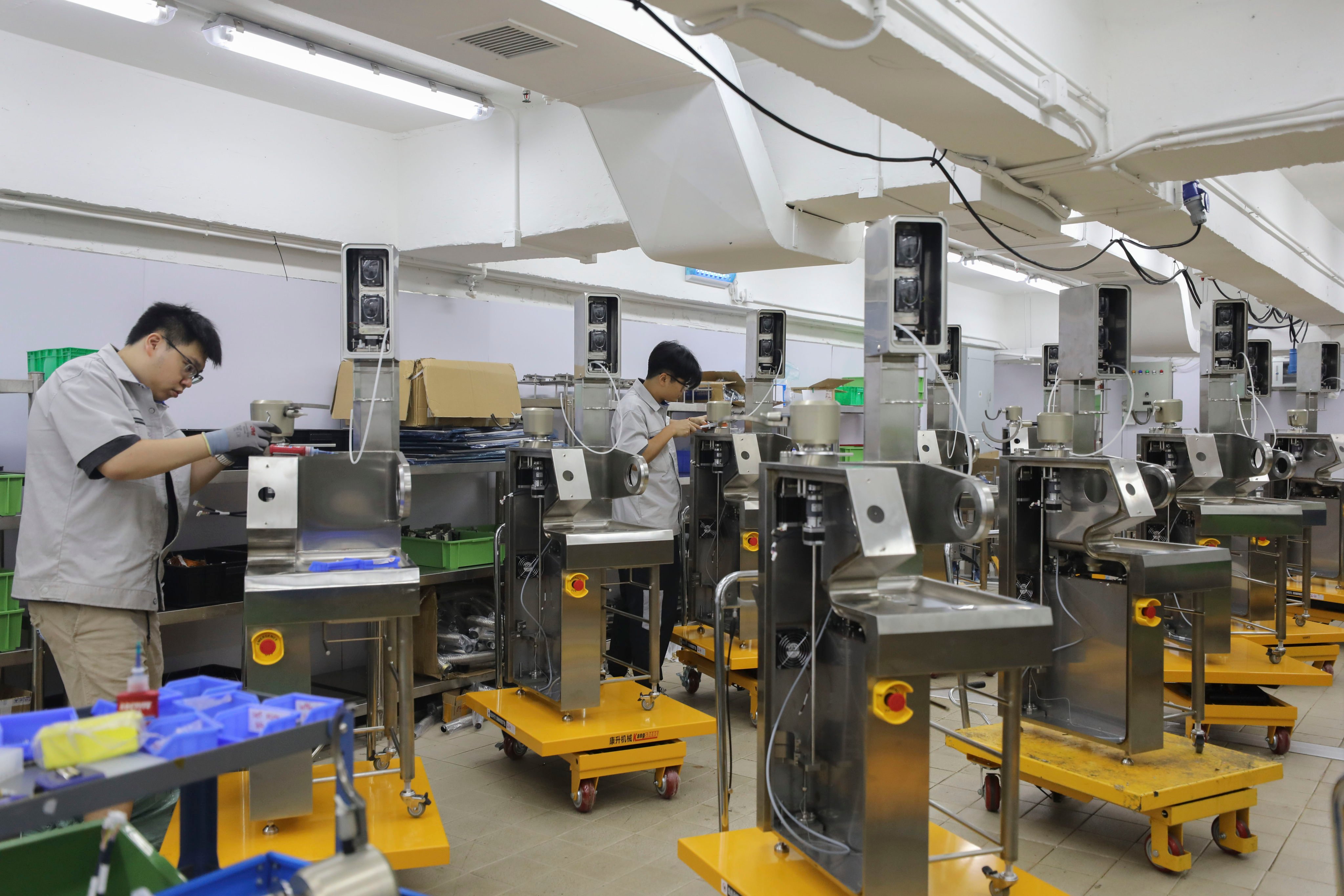 Factory workers assemble the robotic cookers. Photo: Xiaomei Chen