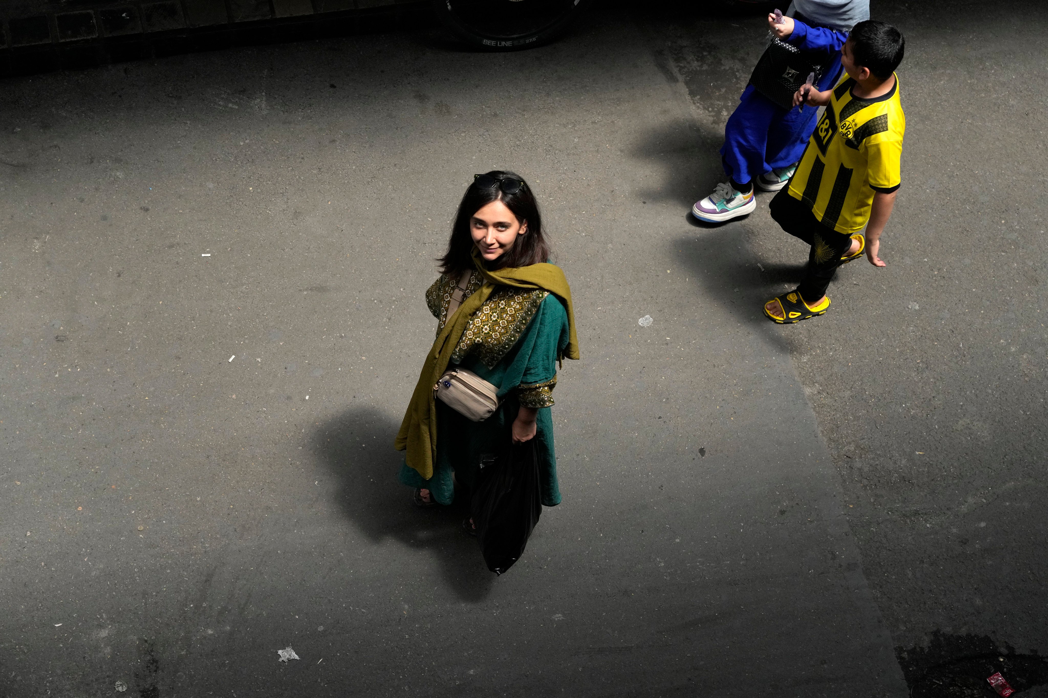 An Iranian woman walks in Tehran, Iran, without a hijab in June. Photo: AP