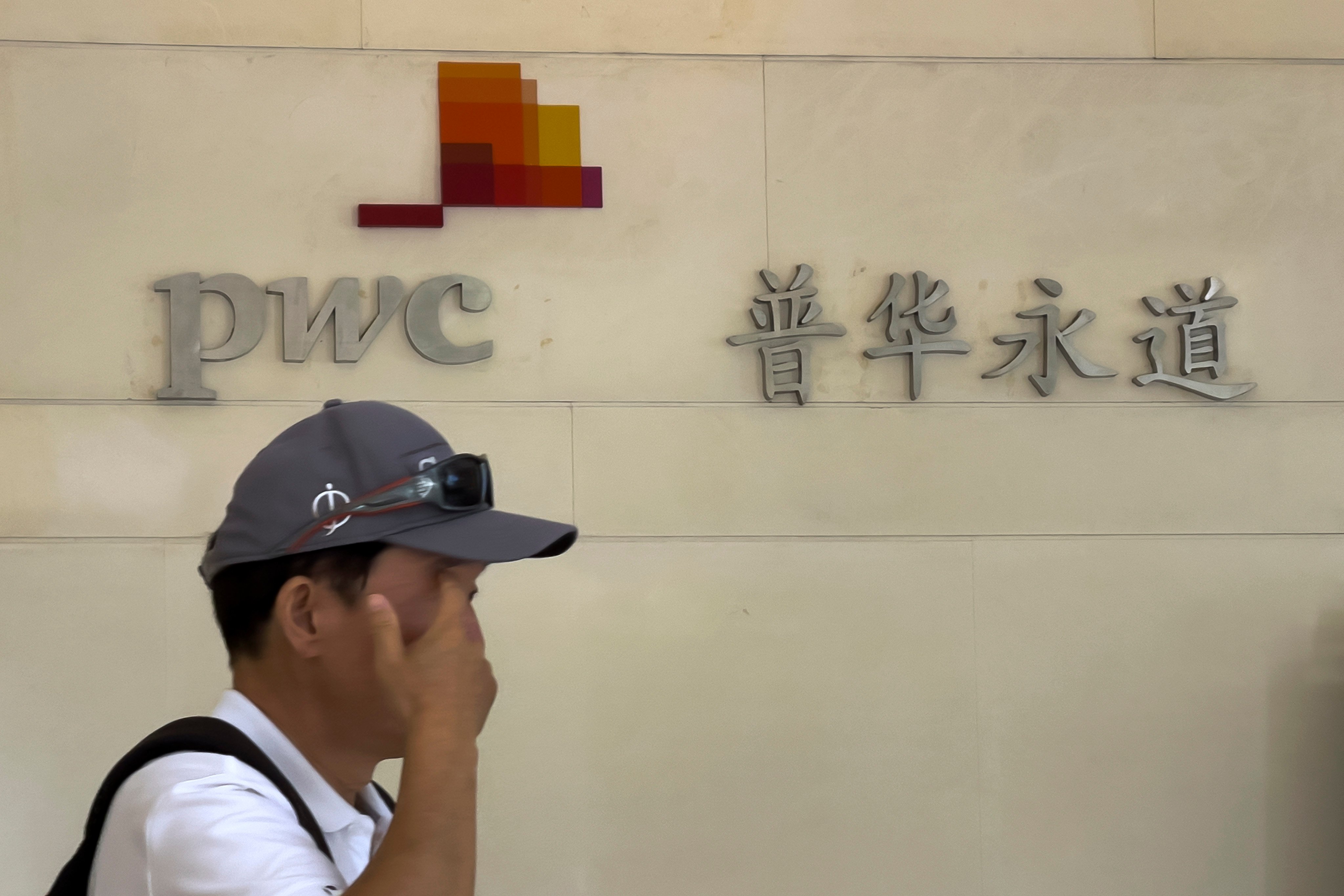 A man walks by the audit firm PricewaterhouseCoopers (PWC) office, at the Fortune Financial Center in Beijing on August 27, 2024. Photo: AP.