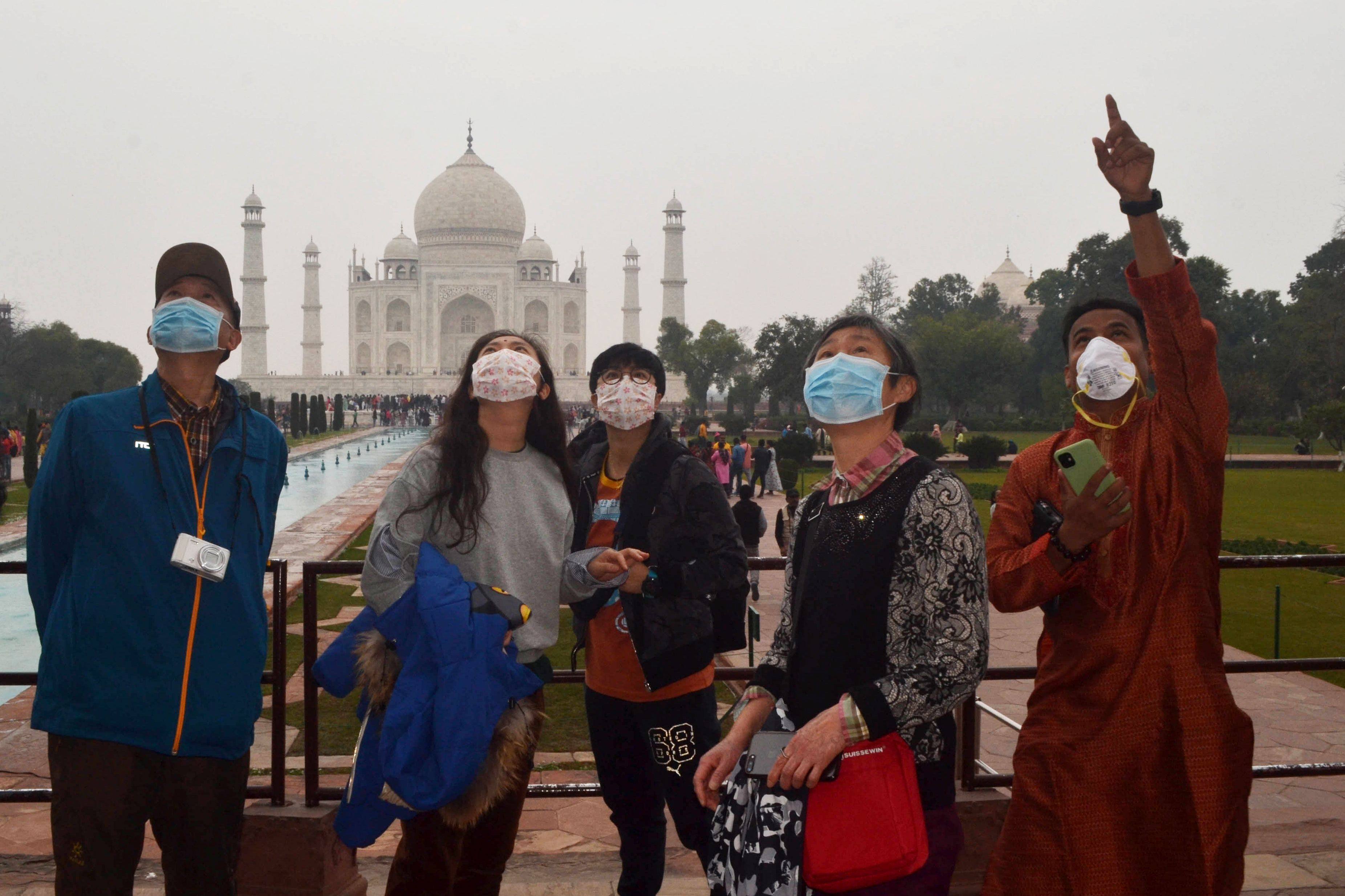 Chinese tourists listen to their guide during a group tour visit at the Taj Mahal in Agra, India, in January 2020. Photo: AFP