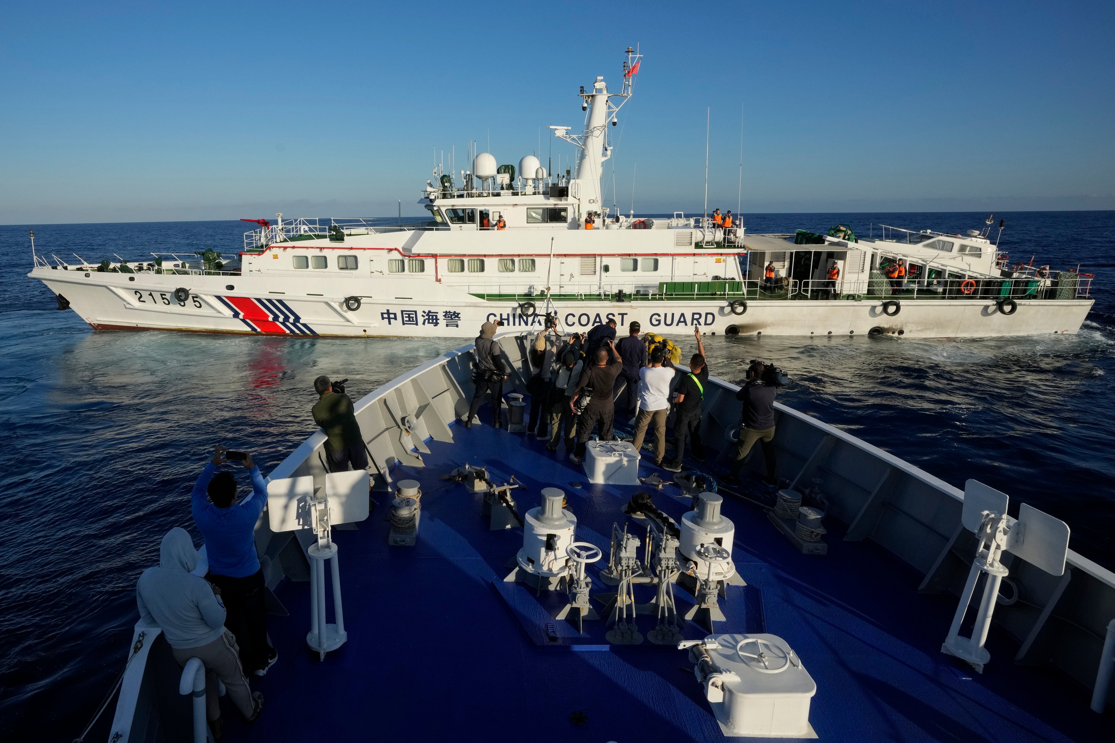 Filipino journalists on board a Philippine coastguard ship report on a Chinese vessel blocking their path in the South China Sea earlier this year. Photo: AP