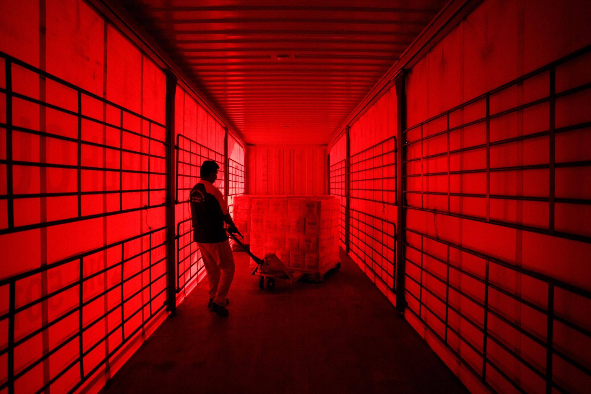 A worker uses a trolley to wheel a pallet of orders from a truck at a 99 Speed Mart warehouse in Negeri Sembilan, Malaysia. Photo: Bloomberg