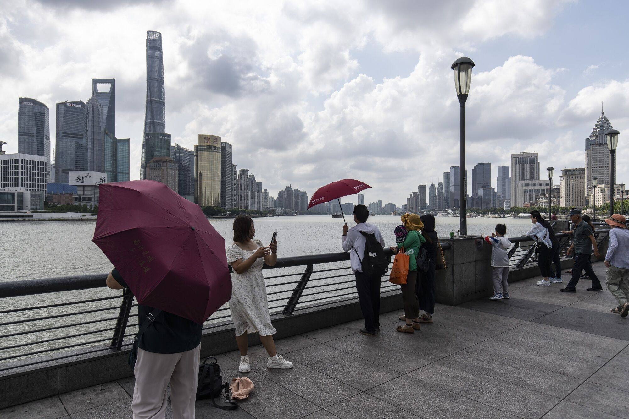 Pedestrians walk along the Bund across from commercial buildings in the Lujiazui financial district in Shanghai, on August 14. Photo: Bloomberg