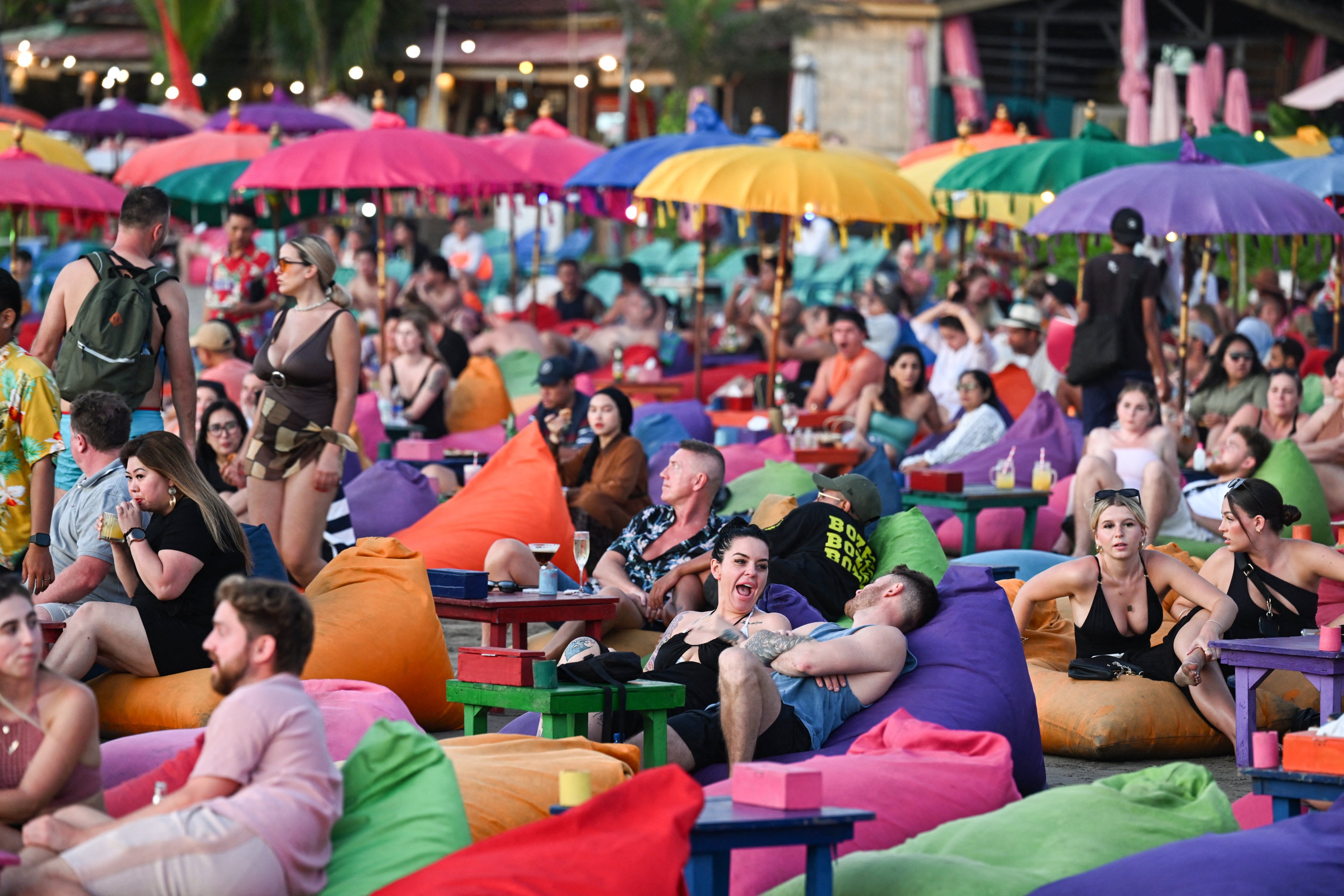 Foreign tourists relax on the Kuta Beach near Denpasar on Indonesia’s resort island of Bali. Photo: AFP